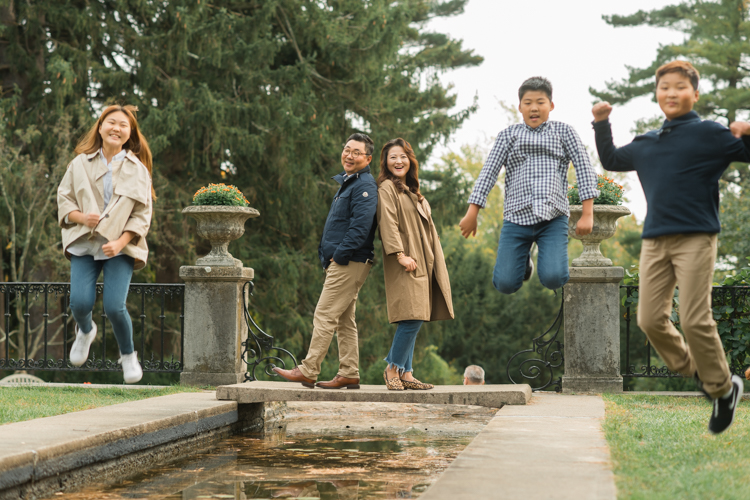 Esther and Thomas’ Fall family session at NJ Botanical Garden with three of their older children were so much to photograph since older kids tend to follow direction better. But I can not do cute little poses that I do with younger children. I thought to myself what would Wes Anderson do? Something more abstract and something fun. Bigger and older kids needed big actions and something not cheesy. Photographing older kids were bit challenging at first but I think we all had some fun and got some good photos for Esther and Thomas’ family. Esther and Thomas’ fall family session at NJ Botanical Garden photographed by Karis from Hey Karis. Photograph is like freezing time, motion in print, movie turned into a book.