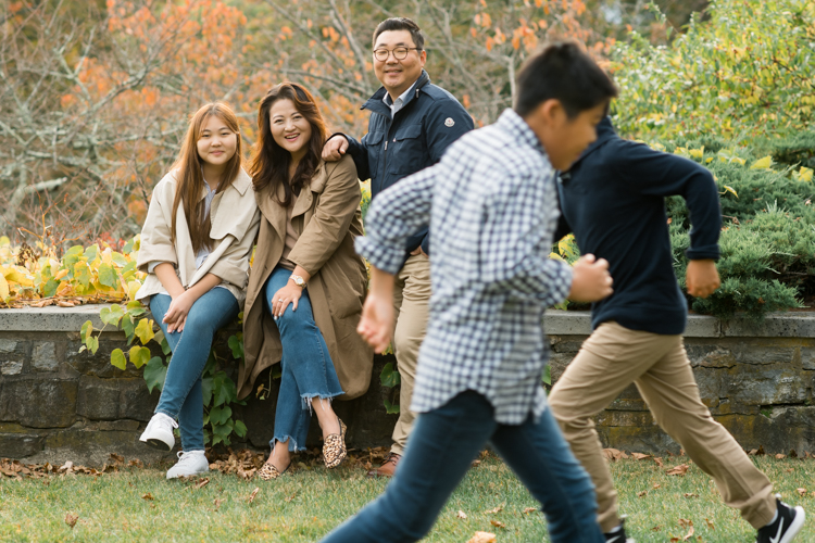 Esther and Thomas’ Fall family session at NJ Botanical Garden with three of their older children were so much to photograph since older kids tend to follow direction better. But I can not do cute little poses that I do with younger children. I thought to myself what would Wes Anderson do? Something more abstract and something fun. Bigger and older kids needed big actions and something not cheesy. Photographing older kids were bit challenging at first but I think we all had some fun and got some good photos for Esther and Thomas’ family. Esther and Thomas’ fall family session at NJ Botanical Garden photographed by Karis from Hey Karis. Photograph is like freezing time, motion in print, movie turned into a book.