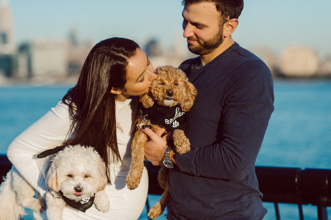 Very hot & sunny afternoon in November I met with Sam and Nick for the maternity session. This expecting parents brought their two fur babies out with them in the hopes of getting some photos of just four before the baby comes next months. Their puppies Cats and Cabo are shih-poos (shih Tzu and Toy Poodle mix) and are too adorable. With Case, Cabo walking along their parents sides we walked along the waterfront of Hoboken NJ. Sam was literally glowing like a porcelain doll and Nick looked so excited and a bit nervous for boy’s arrival. Sam and Nick’s maternity/family session in Hoboken NJ photographed by Karis from Hey Karis. Photograph is like freezing time, motion in print, movie turned into a book. Now booking 2021 and 2022 weddings.