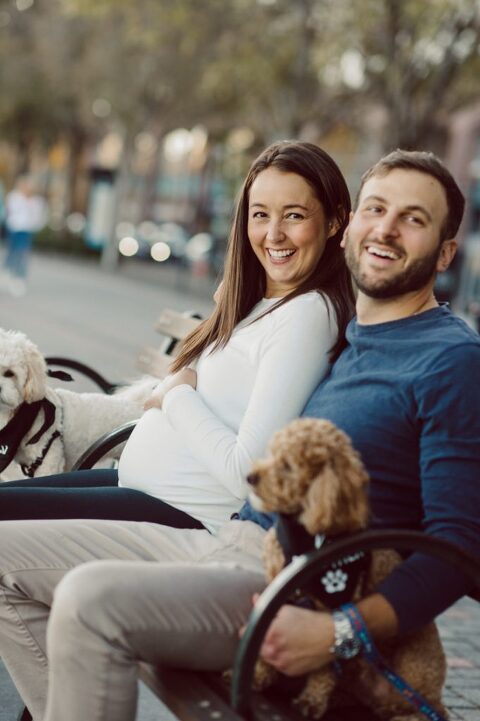 Very hot & sunny afternoon in November I met with Sam and Nick for the maternity session. This expecting parents brought their two fur babies out with them in the hopes of getting some photos of just four before the baby comes next months. Their puppies Cats and Cabo are shih-poos (shih Tzu and Toy Poodle mix) and are too adorable. With Case, Cabo walking along their parents sides we walked along the waterfront of Hoboken NJ. Sam was literally glowing like a porcelain doll and Nick looked so excited and a bit nervous for boy’s arrival. Sam and Nick’s maternity/family session in Hoboken NJ photographed by Karis from Hey Karis. Photograph is like freezing time, motion in print, movie turned into a book. Now booking 2021 and 2022 weddings.