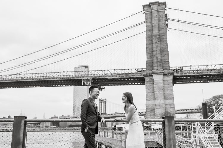 DUMBO Brooklyn NY photographing Stella and Peter's engagement. Temperature dropped dramatically, sky was covered in cloud and was windy but you can't possibly tell by Stella's chic outfit, white strap dress with white kitten heel mules and Peter in his suit and a Gucci tie. Per their outfits, my concept for Stella and Peter's engagement session geared to more editorial. As I shoot I tried to imagine a story in which I want to create and tell through my photos in every session. Stella and Peter's DUMBO Brooklyn Engagement Session captured by NY NJ Documentary Wedding Photographer Karis from Hey Karis, photographing your wedding moments cinematically.