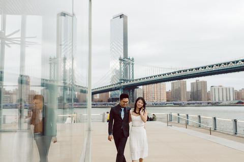 DUMBO Brooklyn NY photographing Stella and Peter's engagement. Temperature dropped dramatically, sky was covered in cloud and was windy but you can't possibly tell by Stella's chic outfit, white strap dress with white kitten heel mules and Peter in his suit and a Gucci tie. Per their outfits, my concept for Stella and Peter's engagement session geared to more editorial. As I shoot I tried to imagine a story in which I want to create and tell through my photos in every session. Stella and Peter's DUMBO Brooklyn Engagement Session captured by NY NJ Documentary Wedding Photographer Karis from Hey Karis, photographing your wedding moments cinematically.