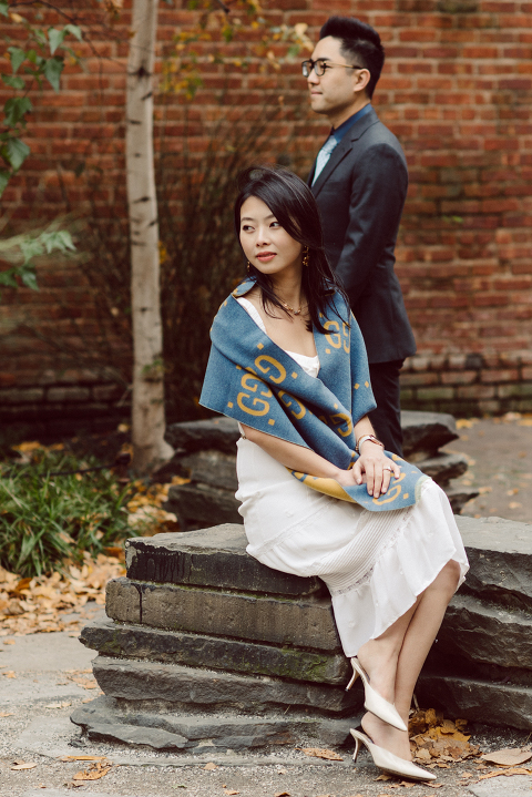 DUMBO Brooklyn NY photographing Stella and Peter's engagement. Temperature dropped dramatically, sky was covered in cloud and was windy but you can't possibly tell by Stella's chic outfit, white strap dress with white kitten heel mules and Peter in his suit and a Gucci tie. Per their outfits, my concept for Stella and Peter's engagement session geared to more editorial. As I shoot I tried to imagine a story in which I want to create and tell through my photos in every session. Stella and Peter's DUMBO Brooklyn Engagement Session captured by NY NJ Documentary Wedding Photographer Karis from Hey Karis, photographing your wedding moments cinematically.