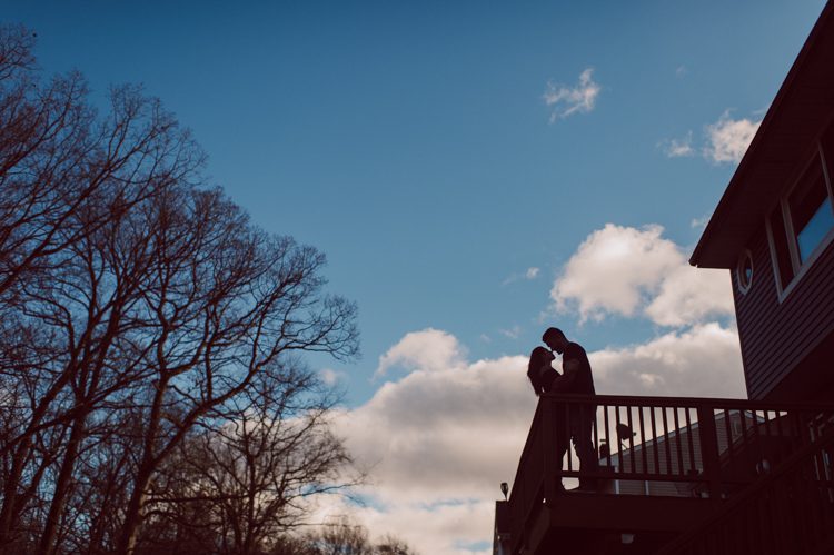 When Cristina and Nick mentioned that they want to do a day in the life, lifestyle type of engagement session at comfort of their home I was all in. What other places on earth other than your home describes you the most! You are most comfortable in your own home, and it shows in these engagement photos of Cristina and Nick that they were cozy. I sensed that Cristina and Nick were both bit shy, quiet, introverts so doing their engagement session at their home made it easier for them to open up and warm up to me. They showed me around their house, telling me stories about the electric guitars on the wall, plants, Nick's mom's snowman collections and into the basement where I saw Nick's Marvel and Super Hero collections. We took photos in all their familiar spaces around the house then out back by the fire pit where Nick had already started the fire before I came. Cristina and Nick told me that's where they love to hang out the most, fire pit with drinks in their hands, cozying up with a blanket over them. Funny story, Cristina and Nick's first date was at the house because they met in the beginning of COVID lockdown and had no where to go so Nick lite the fire pit and they had their romantic fire pit first date. And rest is history! So their engagement session at home in Wayne just made sense. Before the session was over we had to take one last photo with super hero helmet! of course Nick picks Iron Man and Cristina got stuck w Ant Man. I loved Cristina and Nick's calm vibe and getting to know them through my lens during their home engagement session captured by NY NJ Documentary Wedding Photographer Karis from Hey Karis, photographing your wedding, capturing your love and documenting your life.