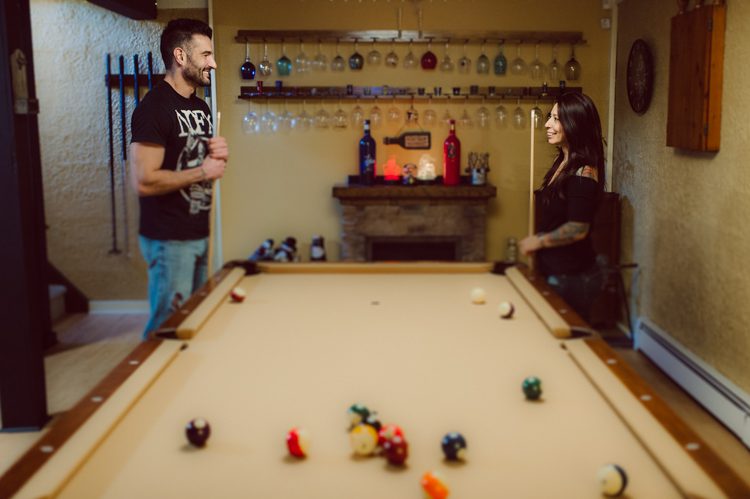 When Cristina and Nick mentioned that they want to do a day in the life, lifestyle type of engagement session at comfort of their home I was all in. What other places on earth other than your home describes you the most! You are most comfortable in your own home, and it shows in these engagement photos of Cristina and Nick that they were cozy. I sensed that Cristina and Nick were both bit shy, quiet, introverts so doing their engagement session at their home made it easier for them to open up and warm up to me. They showed me around their house, telling me stories about the electric guitars on the wall, plants, Nick's mom's snowman collections and into the basement where I saw Nick's Marvel and Super Hero collections. We took photos in all their familiar spaces around the house then out back by the fire pit where Nick had already started the fire before I came. Cristina and Nick told me that's where they love to hang out the most, fire pit with drinks in their hands, cozying up with a blanket over them. Funny story, Cristina and Nick's first date was at the house because they met in the beginning of COVID lockdown and had no where to go so Nick lite the fire pit and they had their romantic fire pit first date. And rest is history! So their engagement session at home in Wayne just made sense. Before the session was over we had to take one last photo with super hero helmet! of course Nick picks Iron Man and Cristina got stuck w Ant Man. I loved Cristina and Nick's calm vibe and getting to know them through my lens during their home engagement session captured by NY NJ Documentary Wedding Photographer Karis from Hey Karis, photographing your wedding, capturing your love and documenting your life.