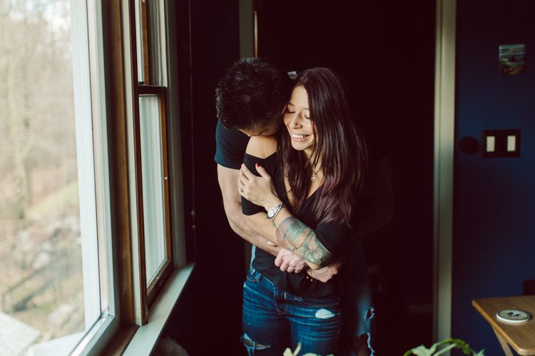 When Cristina and Nick mentioned that they want to do a day in the life, lifestyle type of engagement session at comfort of their home I was all in. What other places on earth other than your home describes you the most! You are most comfortable in your own home, and it shows in these engagement photos of Cristina and Nick that they were cozy. I sensed that Cristina and Nick were both bit shy, quiet, introverts so doing their engagement session at their home made it easier for them to open up and warm up to me. They showed me around their house, telling me stories about the electric guitars on the wall, plants, Nick's mom's snowman collections and into the basement where I saw Nick's Marvel and Super Hero collections. We took photos in all their familiar spaces around the house then out back by the fire pit where Nick had already started the fire before I came. Cristina and Nick told me that's where they love to hang out the most, fire pit with drinks in their hands, cozying up with a blanket over them. Funny story, Cristina and Nick's first date was at the house because they met in the beginning of COVID lockdown and had no where to go so Nick lite the fire pit and they had their romantic fire pit first date. And rest is history! So their engagement session at home in Wayne just made sense. Before the session was over we had to take one last photo with super hero helmet! of course Nick picks Iron Man and Cristina got stuck w Ant Man. I loved Cristina and Nick's calm vibe and getting to know them through my lens during their home engagement session captured by NY NJ Documentary Wedding Photographer Karis from Hey Karis, photographing your wedding, capturing your love and documenting your life.
