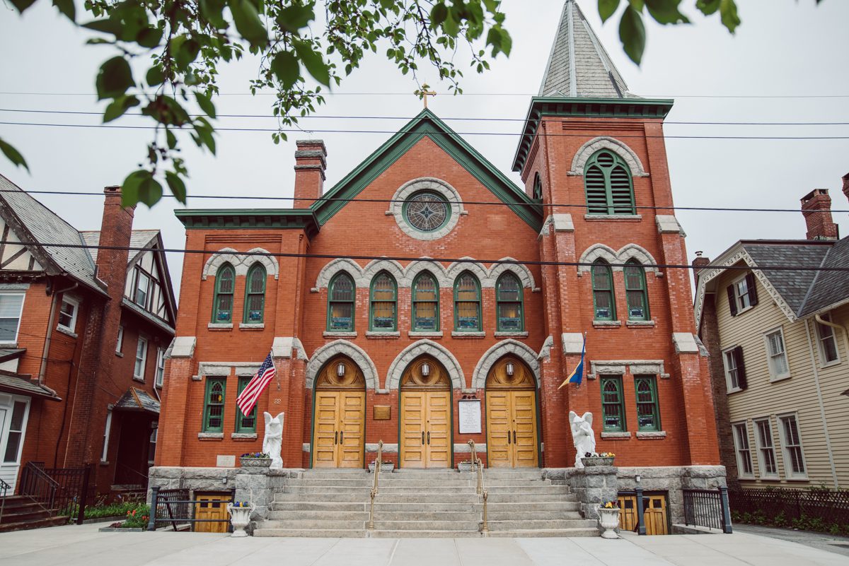 Pulled up to Michell's parents gorgeous mid-century home in Cold Spring, NY on Michelle and Robert's wedding day.  And Robert got ready at an airbnb nearby in Peekskill, NY. Even-though Michelle and Robert had some hiccup with their limo the whole village pulled together and transported Michell and Roberts along with their bridal party to the church Our Lady of Loretto Church to get Michelle and Robert married. Then everyone hoped onto everyone's cars to make their way to West Hills Country Club to party. Michelle and Robert weren't too into taking formal posed portraits but instead wanted to join their friends and guests to enjoy their wedding day, to party, to mingle, to drink and eat the food. Many candid moments were captured, and we wrapped the evening with the most stunning sunset across the field at West Hills Country Club. Michelle and Robert's West Hills Country Club Wedding captured by Hey Karis is NY, NJ, Brooklyn, Hudson Valley and Catskills Wedding and Elopement Photographer.