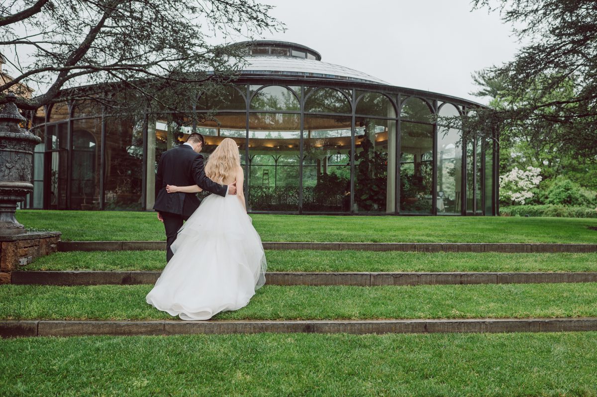 In beautiful Princeton, NJ sits Jasna Polana. This unique wedding venue which is part of TPC Jasna Polana Country Club with it's Tuscany like exterior with cobble stone circular entry way with ground fountain. You'll feel like a royal family when you get married here. It was raining on Hillary and Will's wedding day, so we didn't get to explore the grounds as much as we would have like to but this brave bride Hillary was willing to go out into the rain for outdoor photos on her wedding day. Incredible colors with all the greens, white flowers from the back garden, Hillary's white wedding dress created such a romantic contrast against the deep greens, blues it was such a incredible day. I had such a fun time capturing Hillary and Will on their wedding day at Jasna Polana and can not wait to come back to this gorgeous venue on a dry day to capture more moments. Hillary and Will's Jasna Polana Princeton NJ wedding captured by Karis from Hey Karis NY, NJ, Brooklyn, Hudson Valley and Catskills Wedding and Elopement Photographer.