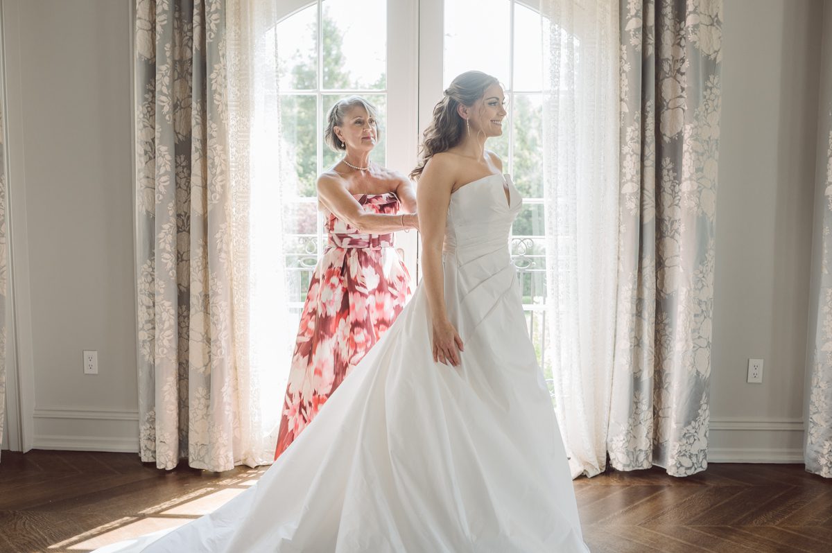 It literally felt like 1000 degrees on Faith and Joe’s wedding at Park Chateau Estate and Gardens. Sun was out and had no plan to hide, not a single cloud in the sky. Despite the gorgeous gardens at Park Chateau Faith and Joe decide to stay cool and alive indoors. I totally don’t blame them, I would much rather be indoor with AC. Thankfully the bridal and groom’s suite at Park Chateau Estate and Gardens is very photogenic with lots of windows. I fully utilized the bridal suite for faith’s getting ready, formal photos with her bridesmaids, first look with her father and her solo photos all before the ceremony. Ceremony was held at the chapel onsite at Park Chateau making everything easy. After the ceremony Faith and Joe did quick few photos outside, some family and group photos then quickly ran indoors before they melted onto the beautiful gardens of Park Chateau. The reception room was filled with peonies and cherry branches it was gorgeous, perfect HOT spring wedding decor. Faith and Joe enjoyed their wedding day the way they wanted by eating drinking and dancing mingling with their guests inside under Cool AC. Faith and Joe’s Park Chateau Estate and Gardens Wedding captured by Karis from Hey Karis NY, NJ, Brooklyn, Hudson Valley and Catskills Wedding and Elopement Photographer.