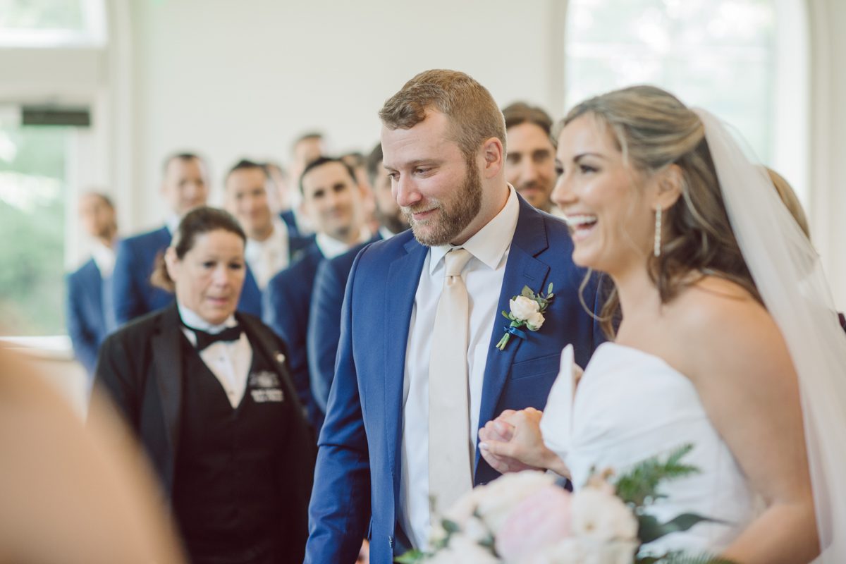 It literally felt like 1000 degrees on Faith and Joe’s wedding at Park Chateau Estate and Gardens. Sun was out and had no plan to hide, not a single cloud in the sky. Despite the gorgeous gardens at Park Chateau Faith and Joe decide to stay cool and alive indoors. I totally don’t blame them, I would much rather be indoor with AC. Thankfully the bridal and groom’s suite at Park Chateau Estate and Gardens is very photogenic with lots of windows. I fully utilized the bridal suite for faith’s getting ready, formal photos with her bridesmaids, first look with her father and her solo photos all before the ceremony. Ceremony was held at the chapel onsite at Park Chateau making everything easy. After the ceremony Faith and Joe did quick few photos outside, some family and group photos then quickly ran indoors before they melted onto the beautiful gardens of Park Chateau. The reception room was filled with peonies and cherry branches it was gorgeous, perfect HOT spring wedding decor. Faith and Joe enjoyed their wedding day the way they wanted by eating drinking and dancing mingling with their guests inside under Cool AC. Faith and Joe’s Park Chateau Estate and Gardens Wedding captured by Karis from Hey Karis NY, NJ, Brooklyn, Hudson Valley and Catskills Wedding and Elopement Photographer.