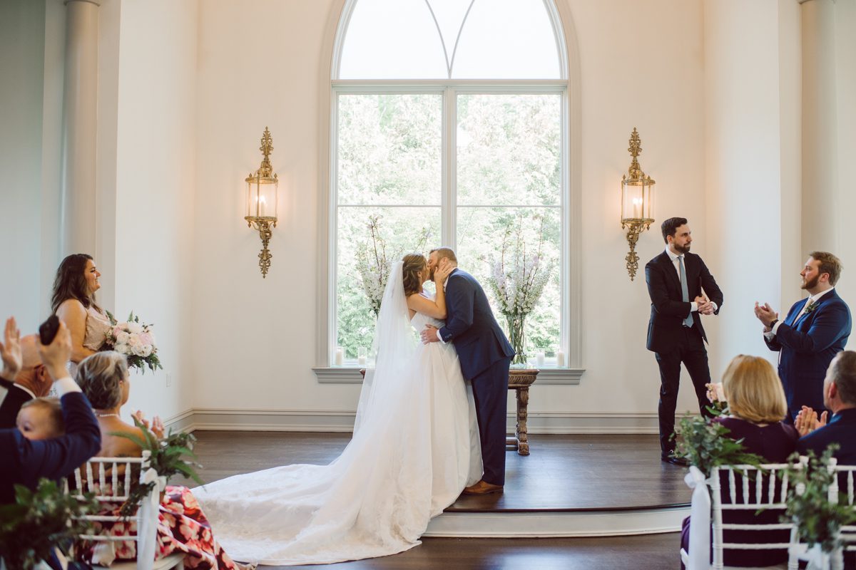 It literally felt like 1000 degrees on Faith and Joe’s wedding at Park Chateau Estate and Gardens. Sun was out and had no plan to hide, not a single cloud in the sky. Despite the gorgeous gardens at Park Chateau Faith and Joe decide to stay cool and alive indoors. I totally don’t blame them, I would much rather be indoor with AC. Thankfully the bridal and groom’s suite at Park Chateau Estate and Gardens is very photogenic with lots of windows. I fully utilized the bridal suite for faith’s getting ready, formal photos with her bridesmaids, first look with her father and her solo photos all before the ceremony. Ceremony was held at the chapel onsite at Park Chateau making everything easy. After the ceremony Faith and Joe did quick few photos outside, some family and group photos then quickly ran indoors before they melted onto the beautiful gardens of Park Chateau. The reception room was filled with peonies and cherry branches it was gorgeous, perfect HOT spring wedding decor. Faith and Joe enjoyed their wedding day the way they wanted by eating drinking and dancing mingling with their guests inside under Cool AC. Faith and Joe’s Park Chateau Estate and Gardens Wedding captured by Karis from Hey Karis NY, NJ, Brooklyn, Hudson Valley and Catskills Wedding and Elopement Photographer.