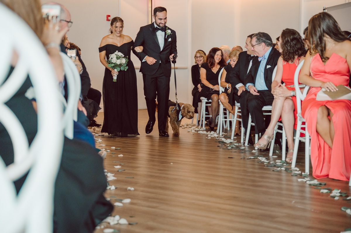 Melanie and Calvin has a fur baby Wilson most adorable Goldendoodle that is a live teddy bear. Wilson is a big part of Melanie and Calvin's lives so they had to have him join in on the wedding celebration at Maritime Parc NJ. Wilson got ready together with Calvin and the guys in the morning while Melanie got ready with her girls and moms. Then we headed to Liberty State Park where Maritime Parc is located in Jersey City, NJ Melanie and Calvin saw each other for the first time, read each other's vows in private under a tree at Liberty State Park, then Wilson joined them for some quick photos. Melanie and Calvin got married under a chuppah in the main ballroom at Maritime Parc, followed by fun night of reception. Melanie and Calvin's Maritime Parc Jersey City NJ wedding captured by Karis from Hey Karis NY, NJ, Brooklyn, Hudson Valley and Catskills Wedding and Elopement Photographer.
