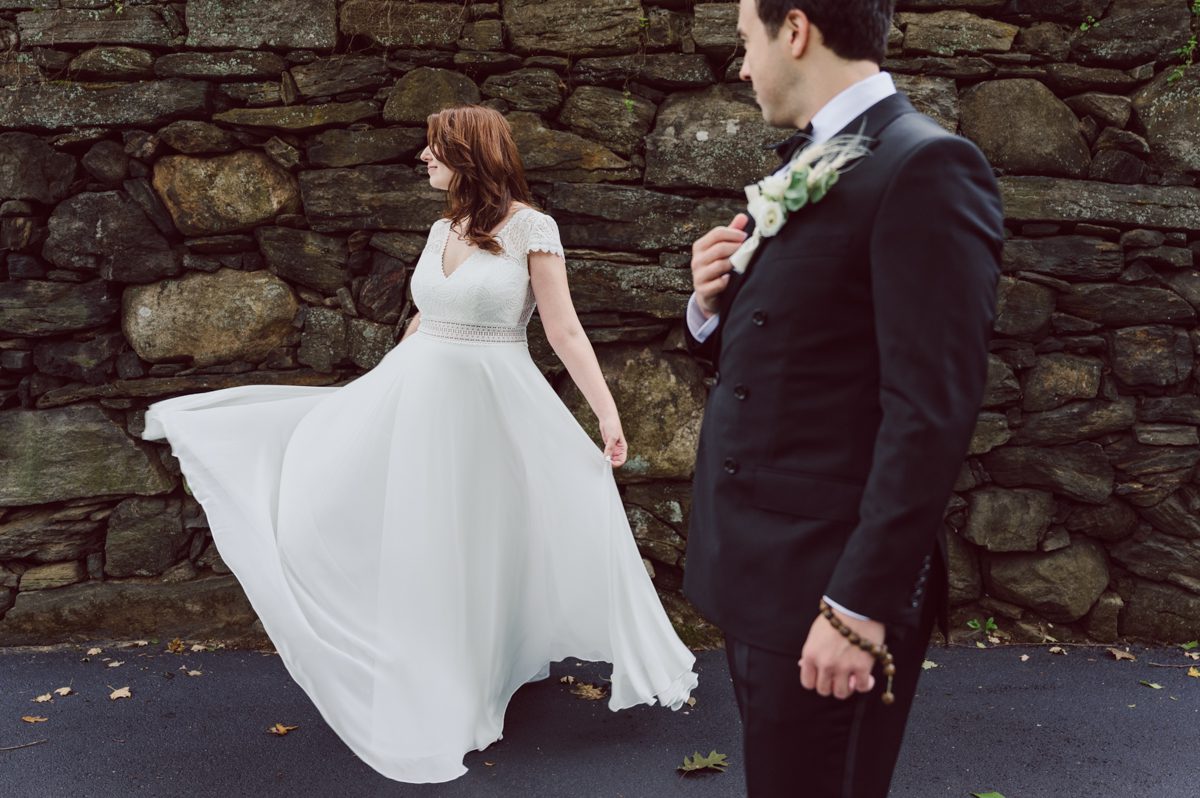 It got chilly over night but at least it wasn't raining. Just overcast which I can deal with and gladly take over rainy wedding day. My drive to Croton on Hudson NY was very smooth and scenic. The neighborhood near the Greta's Lakewood House on Croton on Hudson NY was very picturesque. I love driving through a small winding roads with unique farm houses along the way. Just as Elayne and Alexei explained I saw a white gate house on the Quaker Ridge Road, that I my entrance to Greta's Lakewood House on Croton on Hudson, NY. Drove in to the estate following the long driveway and found the Lakewood House with red door. As I was pulling in to a parking spot I saw Elayne and Alexei come out of the back door together holding a tray of French Fries. Why was I not surprised that they were together on the morning of their wedding day sharing a tray of French Fries together. They looked themselves, calm, happy and in love. I was early, so I walked around the property getting some landscape and exterior photo of this beautiful place. Elayne and Alexei of course got ready separately in their own little house on the property on their own. Elayne quietly did her own makeup and hair and got into her wedding dress all on her own! Even put together her own bouquet! I as Alexei getting bit nervous as he was getting ready, reading Elayne's card, wiring his vow. Around only 20 people were invited to this very private, intimate wedding celebration. Elayne and Alexei looking at each other read their wedding vows, ring on each hand, broke the glass and kissed. The rest of the day fell in to it's place naturally and organically without any coordinator or wedding planner following around every step of the way. They chatted with friends and family, drank champagne, and sat down for family style dinner. It was such a lovely moment watching everyone sharing meal, laughing and loving. Elayne and Alexei ended their wedding day with a bonfire by the Lakewood House. Elayne and Alexei's intimate Lakewood House Croton on Hudson NY wedding captured by Karis from Hey Karis New York, Brooklyn, Hudson Valley and Catskills Wedding Photographer and NYC Elopement Photographer.