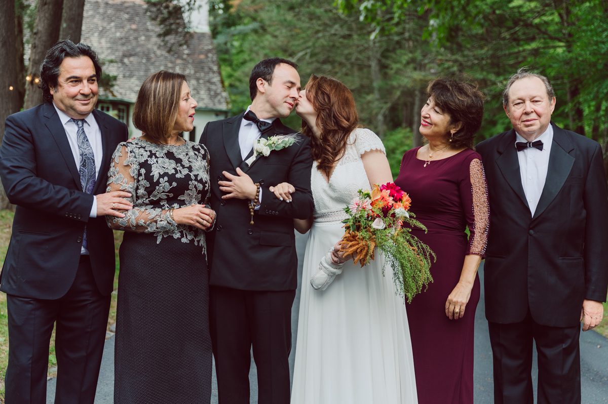 It got chilly over night but at least it wasn't raining. Just overcast which I can deal with and gladly take over rainy wedding day. My drive to Croton on Hudson NY was very smooth and scenic. The neighborhood near the Greta's Lakewood House on Croton on Hudson NY was very picturesque. I love driving through a small winding roads with unique farm houses along the way. Just as Elayne and Alexei explained I saw a white gate house on the Quaker Ridge Road, that I my entrance to Greta's Lakewood House on Croton on Hudson, NY. Drove in to the estate following the long driveway and found the Lakewood House with red door. As I was pulling in to a parking spot I saw Elayne and Alexei come out of the back door together holding a tray of French Fries. Why was I not surprised that they were together on the morning of their wedding day sharing a tray of French Fries together. They looked themselves, calm, happy and in love. I was early, so I walked around the property getting some landscape and exterior photo of this beautiful place. Elayne and Alexei of course got ready separately in their own little house on the property on their own. Elayne quietly did her own makeup and hair and got into her wedding dress all on her own! Even put together her own bouquet! I as Alexei getting bit nervous as he was getting ready, reading Elayne's card, wiring his vow. Around only 20 people were invited to this very private, intimate wedding celebration. Elayne and Alexei looking at each other read their wedding vows, ring on each hand, broke the glass and kissed. The rest of the day fell in to it's place naturally and organically without any coordinator or wedding planner following around every step of the way. They chatted with friends and family, drank champagne, and sat down for family style dinner. It was such a lovely moment watching everyone sharing meal, laughing and loving. Elayne and Alexei ended their wedding day with a bonfire by the Lakewood House. Elayne and Alexei's intimate Lakewood House Croton on Hudson NY wedding captured by Karis from Hey Karis New York, Brooklyn, Hudson Valley and Catskills Wedding Photographer and NYC Elopement Photographer.