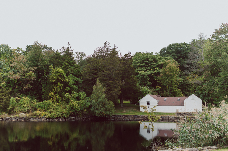 It got chilly over night but at least it wasn't raining. Just overcast which I can deal with and gladly take over rainy wedding day. My drive to Croton on Hudson NY was very smooth and scenic. The neighborhood near the Greta's Lakewood House on Croton on Hudson NY was very picturesque. I love driving through a small winding roads with unique farm houses along the way. Just as Elayne and Alexei explained I saw a white gate house on the Quaker Ridge Road, that I my entrance to Greta's Lakewood House on Croton on Hudson, NY. Drove in to the estate following the long driveway and found the Lakewood House with red door. As I was pulling in to a parking spot I saw Elayne and Alexei come out of the back door together holding a tray of French Fries. Why was I not surprised that they were together on the morning of their wedding day sharing a tray of French Fries together. They looked themselves, calm, happy and in love. I was early, so I walked around the property getting some landscape and exterior photo of this beautiful place. Elayne and Alexei of course got ready separately in their own little house on the property on their own. Elayne quietly did her own makeup and hair and got into her wedding dress all on her own! Even put together her own bouquet! I as Alexei getting bit nervous as he was getting ready, reading Elayne's card, wiring his vow. Around only 20 people were invited to this very private, intimate wedding celebration. Elayne and Alexei looking at each other read their wedding vows, ring on each hand, broke the glass and kissed. The rest of the day fell in to it's place naturally and organically without any coordinator or wedding planner following around every step of the way. They chatted with friends and family, drank champagne, and sat down for family style dinner. It was such a lovely moment watching everyone sharing meal, laughing and loving. Elayne and Alexei ended their wedding day with a bonfire by the Lakewood House. Elayne and Alexei's intimate Lakewood House Croton on Hudson NY wedding captured by Karis from Hey Karis New York, Brooklyn, Hudson Valley and Catskills Wedding Photographer and NYC Elopement Photographer.