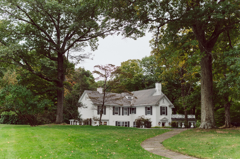 It got chilly over night but at least it wasn't raining. Just overcast which I can deal with and gladly take over rainy wedding day. My drive to Croton on Hudson NY was very smooth and scenic. The neighborhood near the Greta's Lakewood House on Croton on Hudson NY was very picturesque. I love driving through a small winding roads with unique farm houses along the way. Just as Elayne and Alexei explained I saw a white gate house on the Quaker Ridge Road, that I my entrance to Greta's Lakewood House on Croton on Hudson, NY. Drove in to the estate following the long driveway and found the Lakewood House with red door. As I was pulling in to a parking spot I saw Elayne and Alexei come out of the back door together holding a tray of French Fries. Why was I not surprised that they were together on the morning of their wedding day sharing a tray of French Fries together. They looked themselves, calm, happy and in love. I was early, so I walked around the property getting some landscape and exterior photo of this beautiful place. Elayne and Alexei of course got ready separately in their own little house on the property on their own. Elayne quietly did her own makeup and hair and got into her wedding dress all on her own! Even put together her own bouquet! I as Alexei getting bit nervous as he was getting ready, reading Elayne's card, wiring his vow. Around only 20 people were invited to this very private, intimate wedding celebration. Elayne and Alexei looking at each other read their wedding vows, ring on each hand, broke the glass and kissed. The rest of the day fell in to it's place naturally and organically without any coordinator or wedding planner following around every step of the way. They chatted with friends and family, drank champagne, and sat down for family style dinner. It was such a lovely moment watching everyone sharing meal, laughing and loving. Elayne and Alexei ended their wedding day with a bonfire by the Lakewood House. Elayne and Alexei's intimate Lakewood House Croton on Hudson NY wedding captured by Karis from Hey Karis New York, Brooklyn, Hudson Valley and Catskills Wedding Photographer and NYC Elopement Photographer.