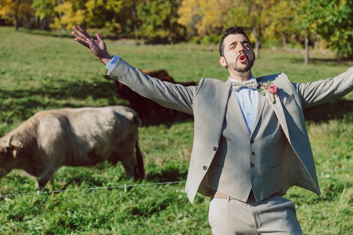 Talking about climate change (global warming) we've been having weirdly warm almost hot Fall. So we were hoping so another warm day for Becca and Dan's wedding on October 8, 2022 but unfortunately non of us were that lucky and it was pretty chilly. Especially at The Farm at Glenwood Mountain NJ which is pretty Northern NJ it felt or was colder, windier and just chillier. Thankfully I brought the right jacket for the chilly wind on the top of Glenwood Mountain but OMG I felt so bad for my bride Becca only wearing her lace wedding dress standing outside on top of Glenwood Mountain during the wedding ceremony. But before I talk about the wedding ceremony let's start from Becca and Dan's wedding prep which took place onsite at The Farm at Glenwood Mountain in Sussex NJ. Becca got ready cozy in the bridal suit when Dan just got ready by the Barn at The Farm at Glenwood Mountain and we went straight into Becca and Dan's first look next to the Highland Cows! Cutest fluffy Highland Cows were all out by the field and chilled while we took some wedding portraits of Becca and Dan. One of the many reasons "I LOVE" this wedding venue "The Farm at Glenwood Mountain" is because of these adorable Fluffy Cows called Highland Cows! I can stare at the all day long and take photo of them all day long. After Becca and Dan's first look, wedding portraits and family photos were done I walked up to the hill to Becca and Dan's outdoor ceremony area on top of the hill at The Farm at Glenwood Mountain and along the way I saw more cute baby Highland Cows to photograph and stare and wave hello. Watched guests arrive in a Yellow School bus in any rustic Farm wedding style and was them walk up the hill. Following the path, the fence with The Barn at their backdrop. Sun was out, it was clear gorgeous day but bit chilly and definitely way windy on top of the hill. My groom Dan came up along with their dog Dash (Dasher), then finally Becca arrived with her parents along side her. Ceremony started quickly knowing that guests and bride probably are freezing, Wind kept moving the cloud in and out making me change my exposure non stop. Wind blew hard, moving Becca's hair all over the place. But non the less it was sincere and beautiful wedding ceremony surrounded by nature, trees and Highland Cows Becca and Dan said their wedding vows followed by I do's. Sealing the wedding ceremony with a kiss Becca and Dan walked down the aisle quickly as possible to bundle Becca in to something warm. Amazing food, spread and hors d'oeuvres were passed out and when the sun was setting everyone made their way in to the barn for warmth and to seated for Becca and Dan's wedding reception. Gorgeous structured barn at The Farm at Glenwood Mountain is definitely not your typical too rustic and broken down barn, the barn here is new, clean, architectural and gorgeous! The owner Chef Steve even makes everyone take off their shoes if we need to enter the barn before the reception. Just like that Becca and Dan danced and partied their way into the night and it was already time for their barn fire and s'mores time outside. Becca and Dan's The Farm at Glenwood Mountain Sussex NJ wedding captured by Karis from Hey Karis New York, Brooklyn, Hudson Valley and Catskills Wedding Photographer and NYC Elopement Photographer.
