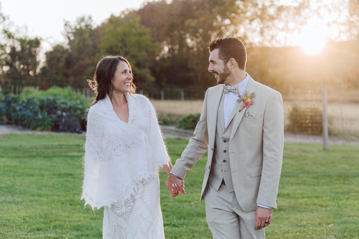 Talking about climate change (global warming) we've been having weirdly warm almost hot Fall. So we were hoping so another warm day for Becca and Dan's wedding on October 8, 2022 but unfortunately non of us were that lucky and it was pretty chilly. Especially at The Farm at Glenwood Mountain NJ which is pretty Northern NJ it felt or was colder, windier and just chillier. Thankfully I brought the right jacket for the chilly wind on the top of Glenwood Mountain but OMG I felt so bad for my bride Becca only wearing her lace wedding dress standing outside on top of Glenwood Mountain during the wedding ceremony. But before I talk about the wedding ceremony let's start from Becca and Dan's wedding prep which took place onsite at The Farm at Glenwood Mountain in Sussex NJ. Becca got ready cozy in the bridal suit when Dan just got ready by the Barn at The Farm at Glenwood Mountain and we went straight into Becca and Dan's first look next to the Highland Cows! Cutest fluffy Highland Cows were all out by the field and chilled while we took some wedding portraits of Becca and Dan. One of the many reasons "I LOVE" this wedding venue "The Farm at Glenwood Mountain" is because of these adorable Fluffy Cows called Highland Cows! I can stare at the all day long and take photo of them all day long. After Becca and Dan's first look, wedding portraits and family photos were done I walked up to the hill to Becca and Dan's outdoor ceremony area on top of the hill at The Farm at Glenwood Mountain and along the way I saw more cute baby Highland Cows to photograph and stare and wave hello. Watched guests arrive in a Yellow School bus in any rustic Farm wedding style and was them walk up the hill. Following the path, the fence with The Barn at their backdrop. Sun was out, it was clear gorgeous day but bit chilly and definitely way windy on top of the hill. My groom Dan came up along with their dog Dash (Dasher), then finally Becca arrived with her parents along side her. Ceremony started quickly knowing that guests and bride probably are freezing, Wind kept moving the cloud in and out making me change my exposure non stop. Wind blew hard, moving Becca's hair all over the place. But non the less it was sincere and beautiful wedding ceremony surrounded by nature, trees and Highland Cows Becca and Dan said their wedding vows followed by I do's. Sealing the wedding ceremony with a kiss Becca and Dan walked down the aisle quickly as possible to bundle Becca in to something warm. Amazing food, spread and hors d'oeuvres were passed out and when the sun was setting everyone made their way in to the barn for warmth and to seated for Becca and Dan's wedding reception. Gorgeous structured barn at The Farm at Glenwood Mountain is definitely not your typical too rustic and broken down barn, the barn here is new, clean, architectural and gorgeous! The owner Chef Steve even makes everyone take off their shoes if we need to enter the barn before the reception. Just like that Becca and Dan danced and partied their way into the night and it was already time for their barn fire and s'mores time outside. Becca and Dan's The Farm at Glenwood Mountain Sussex NJ wedding captured by Karis from Hey Karis New York, Brooklyn, Hudson Valley and Catskills Wedding Photographer and NYC Elopement Photographer.
