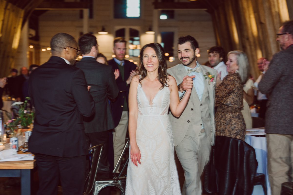 Talking about climate change (global warming) we've been having weirdly warm almost hot Fall. So we were hoping so another warm day for Becca and Dan's wedding on October 8, 2022 but unfortunately non of us were that lucky and it was pretty chilly. Especially at The Farm at Glenwood Mountain NJ which is pretty Northern NJ it felt or was colder, windier and just chillier. Thankfully I brought the right jacket for the chilly wind on the top of Glenwood Mountain but OMG I felt so bad for my bride Becca only wearing her lace wedding dress standing outside on top of Glenwood Mountain during the wedding ceremony. But before I talk about the wedding ceremony let's start from Becca and Dan's wedding prep which took place onsite at The Farm at Glenwood Mountain in Sussex NJ. Becca got ready cozy in the bridal suit when Dan just got ready by the Barn at The Farm at Glenwood Mountain and we went straight into Becca and Dan's first look next to the Highland Cows! Cutest fluffy Highland Cows were all out by the field and chilled while we took some wedding portraits of Becca and Dan. One of the many reasons "I LOVE" this wedding venue "The Farm at Glenwood Mountain" is because of these adorable Fluffy Cows called Highland Cows! I can stare at the all day long and take photo of them all day long. After Becca and Dan's first look, wedding portraits and family photos were done I walked up to the hill to Becca and Dan's outdoor ceremony area on top of the hill at The Farm at Glenwood Mountain and along the way I saw more cute baby Highland Cows to photograph and stare and wave hello. Watched guests arrive in a Yellow School bus in any rustic Farm wedding style and was them walk up the hill. Following the path, the fence with The Barn at their backdrop. Sun was out, it was clear gorgeous day but bit chilly and definitely way windy on top of the hill. My groom Dan came up along with their dog Dash (Dasher), then finally Becca arrived with her parents along side her. Ceremony started quickly knowing that guests and bride probably are freezing, Wind kept moving the cloud in and out making me change my exposure non stop. Wind blew hard, moving Becca's hair all over the place. But non the less it was sincere and beautiful wedding ceremony surrounded by nature, trees and Highland Cows Becca and Dan said their wedding vows followed by I do's. Sealing the wedding ceremony with a kiss Becca and Dan walked down the aisle quickly as possible to bundle Becca in to something warm. Amazing food, spread and hors d'oeuvres were passed out and when the sun was setting everyone made their way in to the barn for warmth and to seated for Becca and Dan's wedding reception. Gorgeous structured barn at The Farm at Glenwood Mountain is definitely not your typical too rustic and broken down barn, the barn here is new, clean, architectural and gorgeous! The owner Chef Steve even makes everyone take off their shoes if we need to enter the barn before the reception. Just like that Becca and Dan danced and partied their way into the night and it was already time for their barn fire and s'mores time outside. Becca and Dan's The Farm at Glenwood Mountain Sussex NJ wedding captured by Karis from Hey Karis New York, Brooklyn, Hudson Valley and Catskills Wedding Photographer and NYC Elopement Photographer.
