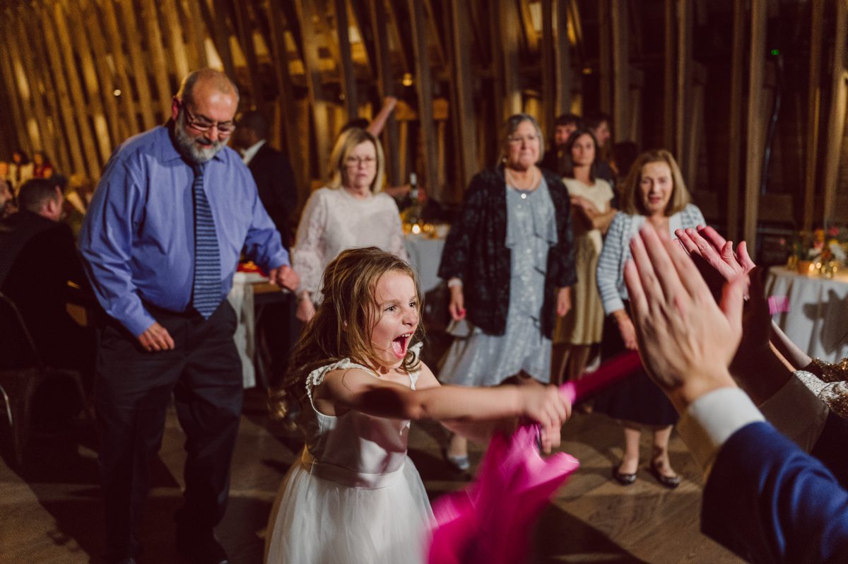 Talking about climate change (global warming) we've been having weirdly warm almost hot Fall. So we were hoping so another warm day for Becca and Dan's wedding on October 8, 2022 but unfortunately non of us were that lucky and it was pretty chilly. Especially at The Farm at Glenwood Mountain NJ which is pretty Northern NJ it felt or was colder, windier and just chillier. Thankfully I brought the right jacket for the chilly wind on the top of Glenwood Mountain but OMG I felt so bad for my bride Becca only wearing her lace wedding dress standing outside on top of Glenwood Mountain during the wedding ceremony. But before I talk about the wedding ceremony let's start from Becca and Dan's wedding prep which took place onsite at The Farm at Glenwood Mountain in Sussex NJ. Becca got ready cozy in the bridal suit when Dan just got ready by the Barn at The Farm at Glenwood Mountain and we went straight into Becca and Dan's first look next to the Highland Cows! Cutest fluffy Highland Cows were all out by the field and chilled while we took some wedding portraits of Becca and Dan. One of the many reasons "I LOVE" this wedding venue "The Farm at Glenwood Mountain" is because of these adorable Fluffy Cows called Highland Cows! I can stare at the all day long and take photo of them all day long. After Becca and Dan's first look, wedding portraits and family photos were done I walked up to the hill to Becca and Dan's outdoor ceremony area on top of the hill at The Farm at Glenwood Mountain and along the way I saw more cute baby Highland Cows to photograph and stare and wave hello. Watched guests arrive in a Yellow School bus in any rustic Farm wedding style and was them walk up the hill. Following the path, the fence with The Barn at their backdrop. Sun was out, it was clear gorgeous day but bit chilly and definitely way windy on top of the hill. My groom Dan came up along with their dog Dash (Dasher), then finally Becca arrived with her parents along side her. Ceremony started quickly knowing that guests and bride probably are freezing, Wind kept moving the cloud in and out making me change my exposure non stop. Wind blew hard, moving Becca's hair all over the place. But non the less it was sincere and beautiful wedding ceremony surrounded by nature, trees and Highland Cows Becca and Dan said their wedding vows followed by I do's. Sealing the wedding ceremony with a kiss Becca and Dan walked down the aisle quickly as possible to bundle Becca in to something warm. Amazing food, spread and hors d'oeuvres were passed out and when the sun was setting everyone made their way in to the barn for warmth and to seated for Becca and Dan's wedding reception. Gorgeous structured barn at The Farm at Glenwood Mountain is definitely not your typical too rustic and broken down barn, the barn here is new, clean, architectural and gorgeous! The owner Chef Steve even makes everyone take off their shoes if we need to enter the barn before the reception. Just like that Becca and Dan danced and partied their way into the night and it was already time for their barn fire and s'mores time outside. Becca and Dan's The Farm at Glenwood Mountain Sussex NJ wedding captured by Karis from Hey Karis New York, Brooklyn, Hudson Valley and Catskills Wedding Photographer and NYC Elopement Photographer.
