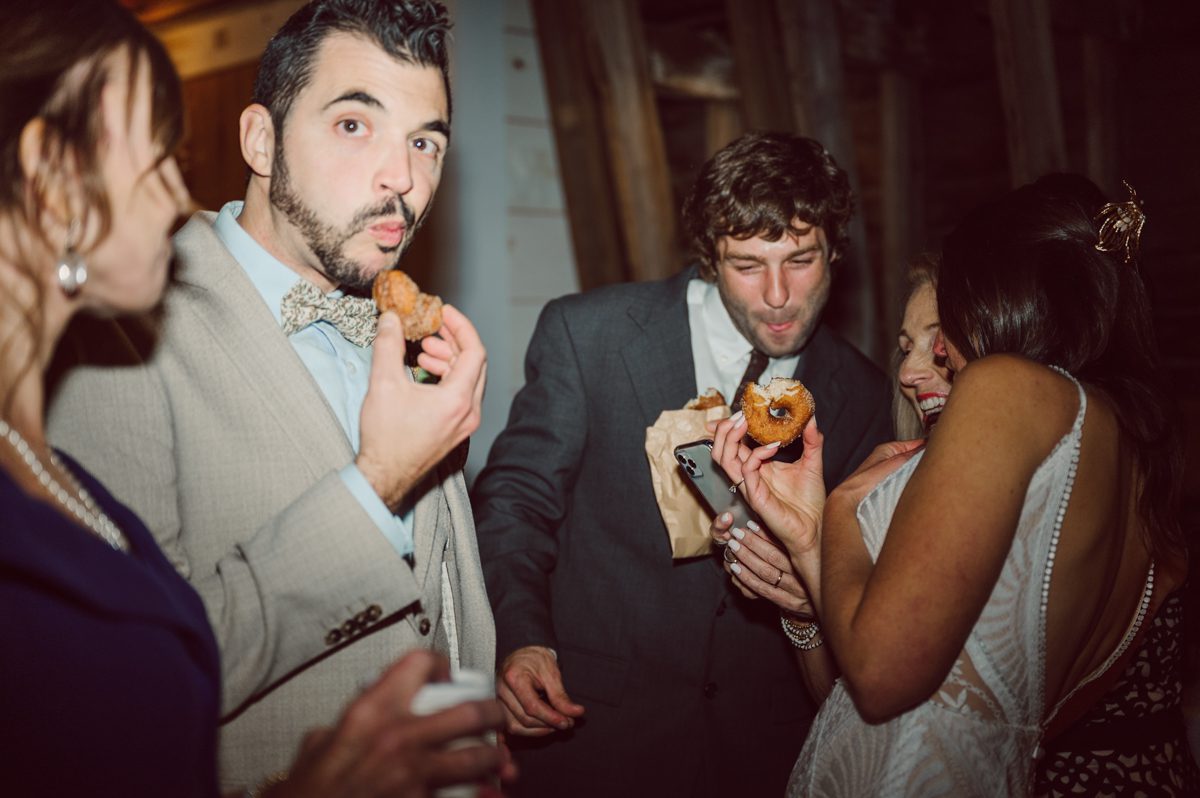 Talking about climate change (global warming) we've been having weirdly warm almost hot Fall. So we were hoping so another warm day for Becca and Dan's wedding on October 8, 2022 but unfortunately non of us were that lucky and it was pretty chilly. Especially at The Farm at Glenwood Mountain NJ which is pretty Northern NJ it felt or was colder, windier and just chillier. Thankfully I brought the right jacket for the chilly wind on the top of Glenwood Mountain but OMG I felt so bad for my bride Becca only wearing her lace wedding dress standing outside on top of Glenwood Mountain during the wedding ceremony. But before I talk about the wedding ceremony let's start from Becca and Dan's wedding prep which took place onsite at The Farm at Glenwood Mountain in Sussex NJ. Becca got ready cozy in the bridal suit when Dan just got ready by the Barn at The Farm at Glenwood Mountain and we went straight into Becca and Dan's first look next to the Highland Cows! Cutest fluffy Highland Cows were all out by the field and chilled while we took some wedding portraits of Becca and Dan. One of the many reasons "I LOVE" this wedding venue "The Farm at Glenwood Mountain" is because of these adorable Fluffy Cows called Highland Cows! I can stare at the all day long and take photo of them all day long. After Becca and Dan's first look, wedding portraits and family photos were done I walked up to the hill to Becca and Dan's outdoor ceremony area on top of the hill at The Farm at Glenwood Mountain and along the way I saw more cute baby Highland Cows to photograph and stare and wave hello. Watched guests arrive in a Yellow School bus in any rustic Farm wedding style and was them walk up the hill. Following the path, the fence with The Barn at their backdrop. Sun was out, it was clear gorgeous day but bit chilly and definitely way windy on top of the hill. My groom Dan came up along with their dog Dash (Dasher), then finally Becca arrived with her parents along side her. Ceremony started quickly knowing that guests and bride probably are freezing, Wind kept moving the cloud in and out making me change my exposure non stop. Wind blew hard, moving Becca's hair all over the place. But non the less it was sincere and beautiful wedding ceremony surrounded by nature, trees and Highland Cows Becca and Dan said their wedding vows followed by I do's. Sealing the wedding ceremony with a kiss Becca and Dan walked down the aisle quickly as possible to bundle Becca in to something warm. Amazing food, spread and hors d'oeuvres were passed out and when the sun was setting everyone made their way in to the barn for warmth and to seated for Becca and Dan's wedding reception. Gorgeous structured barn at The Farm at Glenwood Mountain is definitely not your typical too rustic and broken down barn, the barn here is new, clean, architectural and gorgeous! The owner Chef Steve even makes everyone take off their shoes if we need to enter the barn before the reception. Just like that Becca and Dan danced and partied their way into the night and it was already time for their barn fire and s'mores time outside. Becca and Dan's The Farm at Glenwood Mountain Sussex NJ wedding captured by Karis from Hey Karis New York, Brooklyn, Hudson Valley and Catskills Wedding Photographer and NYC Elopement Photographer.
