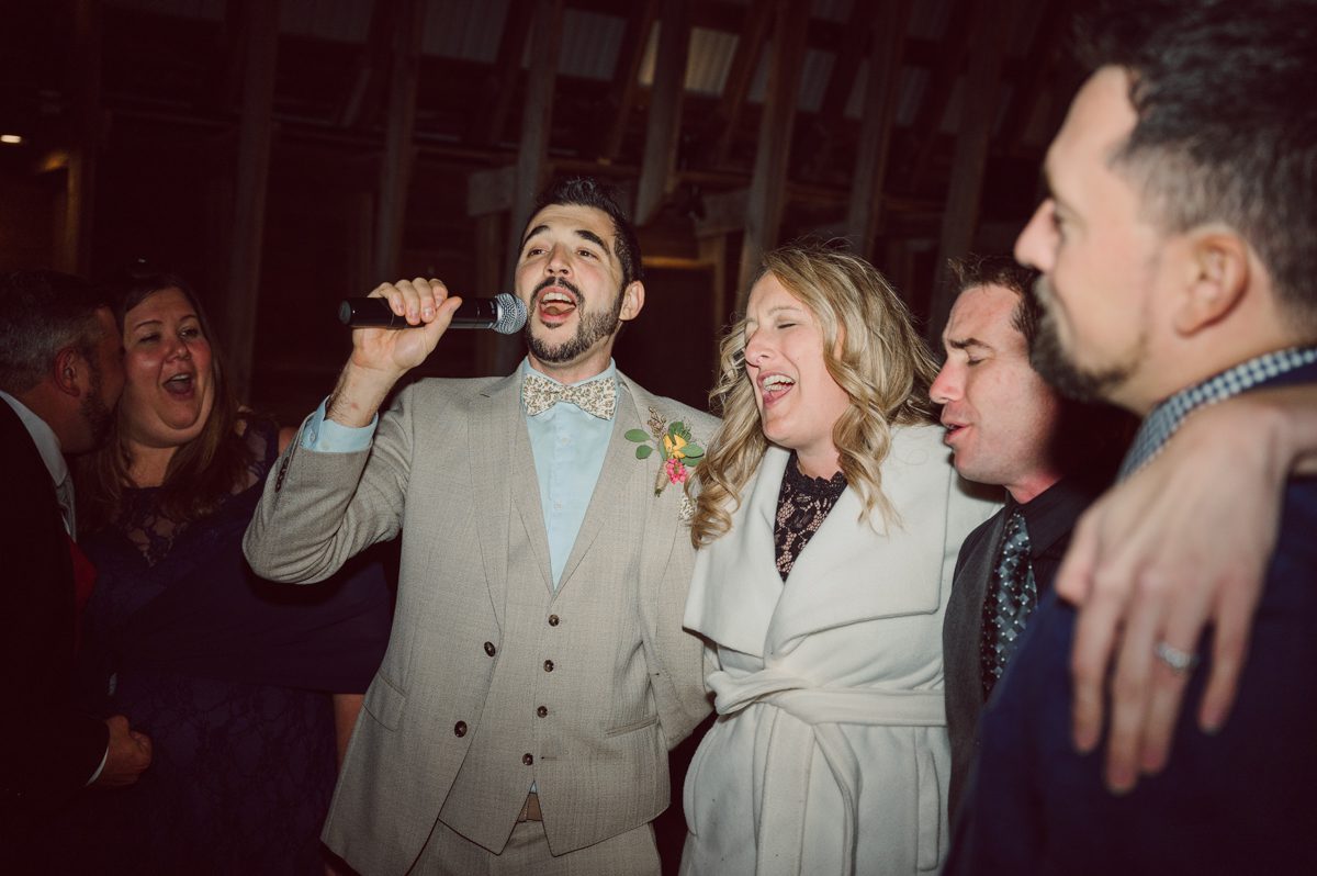 Talking about climate change (global warming) we've been having weirdly warm almost hot Fall. So we were hoping so another warm day for Becca and Dan's wedding on October 8, 2022 but unfortunately non of us were that lucky and it was pretty chilly. Especially at The Farm at Glenwood Mountain NJ which is pretty Northern NJ it felt or was colder, windier and just chillier. Thankfully I brought the right jacket for the chilly wind on the top of Glenwood Mountain but OMG I felt so bad for my bride Becca only wearing her lace wedding dress standing outside on top of Glenwood Mountain during the wedding ceremony. But before I talk about the wedding ceremony let's start from Becca and Dan's wedding prep which took place onsite at The Farm at Glenwood Mountain in Sussex NJ. Becca got ready cozy in the bridal suit when Dan just got ready by the Barn at The Farm at Glenwood Mountain and we went straight into Becca and Dan's first look next to the Highland Cows! Cutest fluffy Highland Cows were all out by the field and chilled while we took some wedding portraits of Becca and Dan. One of the many reasons "I LOVE" this wedding venue "The Farm at Glenwood Mountain" is because of these adorable Fluffy Cows called Highland Cows! I can stare at the all day long and take photo of them all day long. After Becca and Dan's first look, wedding portraits and family photos were done I walked up to the hill to Becca and Dan's outdoor ceremony area on top of the hill at The Farm at Glenwood Mountain and along the way I saw more cute baby Highland Cows to photograph and stare and wave hello. Watched guests arrive in a Yellow School bus in any rustic Farm wedding style and was them walk up the hill. Following the path, the fence with The Barn at their backdrop. Sun was out, it was clear gorgeous day but bit chilly and definitely way windy on top of the hill. My groom Dan came up along with their dog Dash (Dasher), then finally Becca arrived with her parents along side her. Ceremony started quickly knowing that guests and bride probably are freezing, Wind kept moving the cloud in and out making me change my exposure non stop. Wind blew hard, moving Becca's hair all over the place. But non the less it was sincere and beautiful wedding ceremony surrounded by nature, trees and Highland Cows Becca and Dan said their wedding vows followed by I do's. Sealing the wedding ceremony with a kiss Becca and Dan walked down the aisle quickly as possible to bundle Becca in to something warm. Amazing food, spread and hors d'oeuvres were passed out and when the sun was setting everyone made their way in to the barn for warmth and to seated for Becca and Dan's wedding reception. Gorgeous structured barn at The Farm at Glenwood Mountain is definitely not your typical too rustic and broken down barn, the barn here is new, clean, architectural and gorgeous! The owner Chef Steve even makes everyone take off their shoes if we need to enter the barn before the reception. Just like that Becca and Dan danced and partied their way into the night and it was already time for their barn fire and s'mores time outside. Becca and Dan's The Farm at Glenwood Mountain Sussex NJ wedding captured by Karis from Hey Karis New York, Brooklyn, Hudson Valley and Catskills Wedding Photographer and NYC Elopement Photographer.
