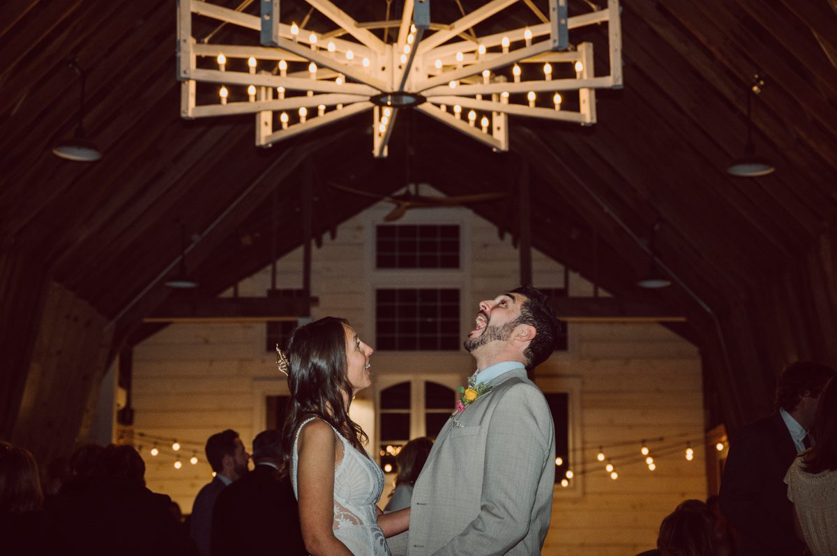 Talking about climate change (global warming) we've been having weirdly warm almost hot Fall. So we were hoping so another warm day for Becca and Dan's wedding on October 8, 2022 but unfortunately non of us were that lucky and it was pretty chilly. Especially at The Farm at Glenwood Mountain NJ which is pretty Northern NJ it felt or was colder, windier and just chillier. Thankfully I brought the right jacket for the chilly wind on the top of Glenwood Mountain but OMG I felt so bad for my bride Becca only wearing her lace wedding dress standing outside on top of Glenwood Mountain during the wedding ceremony. But before I talk about the wedding ceremony let's start from Becca and Dan's wedding prep which took place onsite at The Farm at Glenwood Mountain in Sussex NJ. Becca got ready cozy in the bridal suit when Dan just got ready by the Barn at The Farm at Glenwood Mountain and we went straight into Becca and Dan's first look next to the Highland Cows! Cutest fluffy Highland Cows were all out by the field and chilled while we took some wedding portraits of Becca and Dan. One of the many reasons "I LOVE" this wedding venue "The Farm at Glenwood Mountain" is because of these adorable Fluffy Cows called Highland Cows! I can stare at the all day long and take photo of them all day long. After Becca and Dan's first look, wedding portraits and family photos were done I walked up to the hill to Becca and Dan's outdoor ceremony area on top of the hill at The Farm at Glenwood Mountain and along the way I saw more cute baby Highland Cows to photograph and stare and wave hello. Watched guests arrive in a Yellow School bus in any rustic Farm wedding style and was them walk up the hill. Following the path, the fence with The Barn at their backdrop. Sun was out, it was clear gorgeous day but bit chilly and definitely way windy on top of the hill. My groom Dan came up along with their dog Dash (Dasher), then finally Becca arrived with her parents along side her. Ceremony started quickly knowing that guests and bride probably are freezing, Wind kept moving the cloud in and out making me change my exposure non stop. Wind blew hard, moving Becca's hair all over the place. But non the less it was sincere and beautiful wedding ceremony surrounded by nature, trees and Highland Cows Becca and Dan said their wedding vows followed by I do's. Sealing the wedding ceremony with a kiss Becca and Dan walked down the aisle quickly as possible to bundle Becca in to something warm. Amazing food, spread and hors d'oeuvres were passed out and when the sun was setting everyone made their way in to the barn for warmth and to seated for Becca and Dan's wedding reception. Gorgeous structured barn at The Farm at Glenwood Mountain is definitely not your typical too rustic and broken down barn, the barn here is new, clean, architectural and gorgeous! The owner Chef Steve even makes everyone take off their shoes if we need to enter the barn before the reception. Just like that Becca and Dan danced and partied their way into the night and it was already time for their barn fire and s'mores time outside. Becca and Dan's The Farm at Glenwood Mountain Sussex NJ wedding captured by Karis from Hey Karis New York, Brooklyn, Hudson Valley and Catskills Wedding Photographer and NYC Elopement Photographer.
