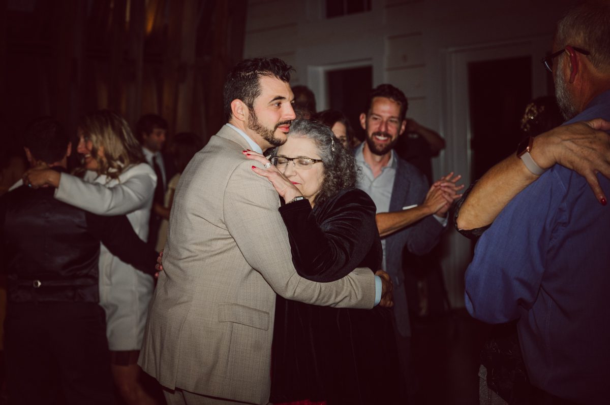 Talking about climate change (global warming) we've been having weirdly warm almost hot Fall. So we were hoping so another warm day for Becca and Dan's wedding on October 8, 2022 but unfortunately non of us were that lucky and it was pretty chilly. Especially at The Farm at Glenwood Mountain NJ which is pretty Northern NJ it felt or was colder, windier and just chillier. Thankfully I brought the right jacket for the chilly wind on the top of Glenwood Mountain but OMG I felt so bad for my bride Becca only wearing her lace wedding dress standing outside on top of Glenwood Mountain during the wedding ceremony. But before I talk about the wedding ceremony let's start from Becca and Dan's wedding prep which took place onsite at The Farm at Glenwood Mountain in Sussex NJ. Becca got ready cozy in the bridal suit when Dan just got ready by the Barn at The Farm at Glenwood Mountain and we went straight into Becca and Dan's first look next to the Highland Cows! Cutest fluffy Highland Cows were all out by the field and chilled while we took some wedding portraits of Becca and Dan. One of the many reasons "I LOVE" this wedding venue "The Farm at Glenwood Mountain" is because of these adorable Fluffy Cows called Highland Cows! I can stare at the all day long and take photo of them all day long. After Becca and Dan's first look, wedding portraits and family photos were done I walked up to the hill to Becca and Dan's outdoor ceremony area on top of the hill at The Farm at Glenwood Mountain and along the way I saw more cute baby Highland Cows to photograph and stare and wave hello. Watched guests arrive in a Yellow School bus in any rustic Farm wedding style and was them walk up the hill. Following the path, the fence with The Barn at their backdrop. Sun was out, it was clear gorgeous day but bit chilly and definitely way windy on top of the hill. My groom Dan came up along with their dog Dash (Dasher), then finally Becca arrived with her parents along side her. Ceremony started quickly knowing that guests and bride probably are freezing, Wind kept moving the cloud in and out making me change my exposure non stop. Wind blew hard, moving Becca's hair all over the place. But non the less it was sincere and beautiful wedding ceremony surrounded by nature, trees and Highland Cows Becca and Dan said their wedding vows followed by I do's. Sealing the wedding ceremony with a kiss Becca and Dan walked down the aisle quickly as possible to bundle Becca in to something warm. Amazing food, spread and hors d'oeuvres were passed out and when the sun was setting everyone made their way in to the barn for warmth and to seated for Becca and Dan's wedding reception. Gorgeous structured barn at The Farm at Glenwood Mountain is definitely not your typical too rustic and broken down barn, the barn here is new, clean, architectural and gorgeous! The owner Chef Steve even makes everyone take off their shoes if we need to enter the barn before the reception. Just like that Becca and Dan danced and partied their way into the night and it was already time for their barn fire and s'mores time outside. Becca and Dan's The Farm at Glenwood Mountain Sussex NJ wedding captured by Karis from Hey Karis New York, Brooklyn, Hudson Valley and Catskills Wedding Photographer and NYC Elopement Photographer.
