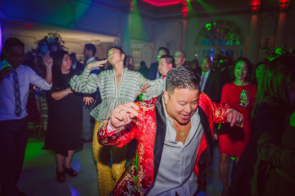 Connie and Richard who are Rick's parents inquired for their son's wedding since his son Rick and soon to be daughter in law currently lives in California and was planning their wedding in the West Coast. Connie and Richard are from here in NJ and was eager to help and plan their son's wedding here in the East Coast. Connie and Richard chose Crystal Plaza in Livingston NJ for their son's wedding venue here in NJ on October 29, 2022. Connie and Richard were delightful parents and young minded for first generation Chinese Americans, their english was fluent as well as their Chinese I was pleasantly surprised since I am second generation Korean-American and my immigrant Korean parents do not speak english that well. It was my first wedding where I did not get to meet the bride and groom till the wedding day. It made me bit nervous as I walked into the bridal suite at Crystal Plaza. But to my surprise Alison and Rick were super sweet and nice where we smoothly worked through the portrait session. Alison and Rick followed all my directions well, did everything I asked them to then it was time for PARTY! Cocktail hour at Crystal Plaza was impressive with spreads and tables of delicious food! I definitely enjoyed some of the delicious food during cocktail hour then walked into the reception room and i was WOWed. The house lights at Crystal Plaza was beautiful and it was actually amazing that I didn't even use my own lights. The mixture of house lights, fog and spotlights at Crystal Plaza was actually fabulous and I was very impressed. The house lights at Crystal Plaza made shutter drag dancing photos with double exposure so much fun and amazing! Alison and Rick, actually Connie and Richard even hired Chinese Lion Dancers for the reception and all the guests loved it. The energy during Alison and Rick's wedding reception was on FIRE! Everyone and anyone was on the dance floor dancing like it was their last one. I truly had a blast during Alison and Rick's wedding at Crystal Plaza in Livingston NJ and looking forward to going back to Crystal Plaza soon. Alison and Rick's Crystal Plaza in Livingston NJ wedding captured by Karis from Hey Karis New York, Brooklyn, Hudson Valley and Catskills Wedding Photographer and NYC Elopement Photographer.