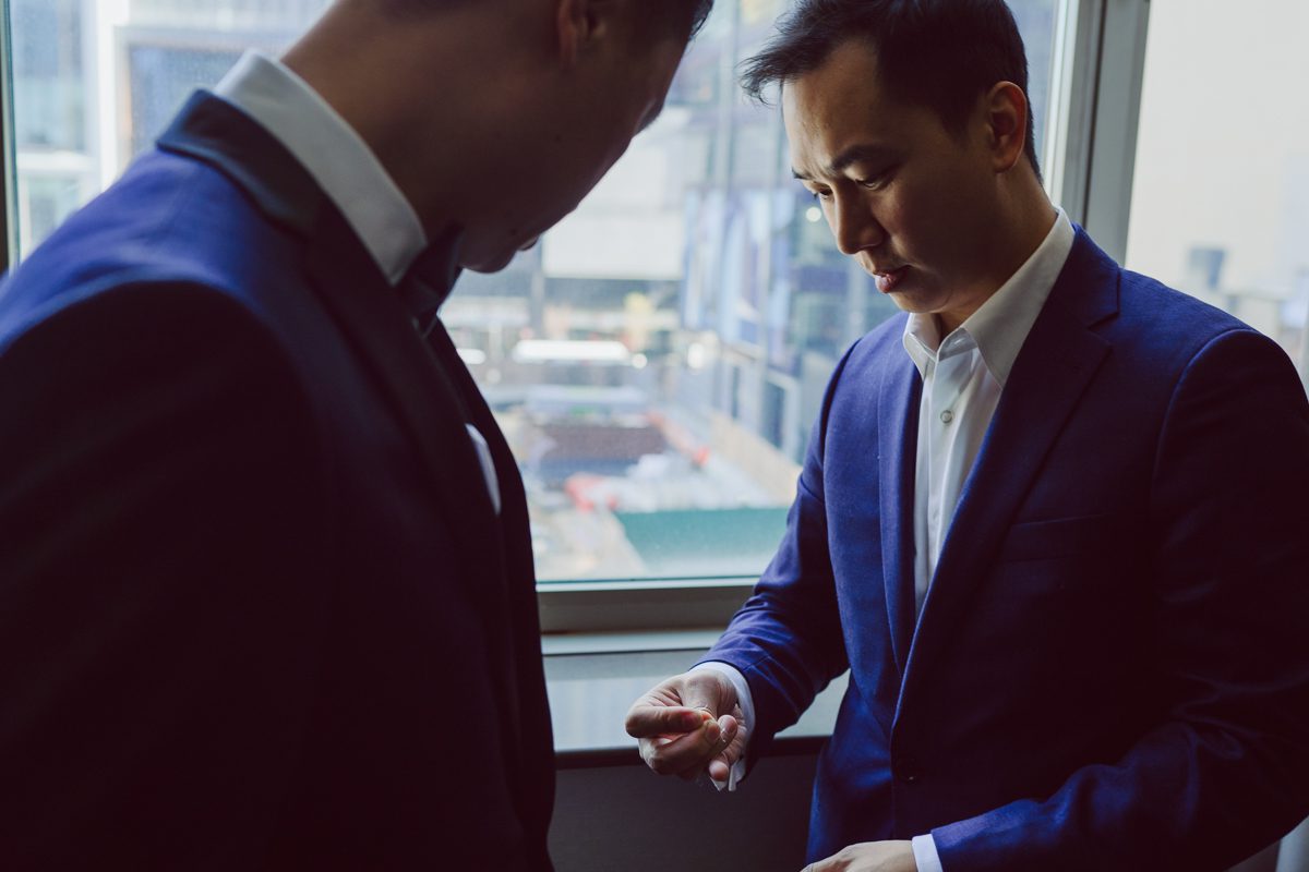 Duffield St, Brooklyn on November 19 even though it's Saturday morning it was still very busy. But luckily I found street parking right on Duffield St in front of Sheraton Downtown Brooklyn which was where I needed to be for Ariana and Jon's wedding prep. Vicky from VickyC5 hair/makeup team was there beautifying the ladies, I went straight to flat lays of Ariana's wedding details such as rings, jewelry and her wedding invitations. I use ribbons, extra loose flowers to make the flat lays more fine art looking. Once all the details are done, my full focus goes to the bride Ariana and her ladies. Ariana and Jon were planning to do a Chinese Door Game at the hotel room, so as soon as Ariana was ready in her Hanbok (Korean Traditional Wedding Outfit) Jon and his groomsmen arrived at the door. With Ariana's bridal suite crowded with too many people Ariana's bridesmaids started to give instructions to the games that Jon and his groomsmen need to play in order to get through the second door so that Jon can meet/see his bride Ariana. While the games are happening outside Ariana's door one of the bridesmaid has her phone on FaceTime so that Ariana can see how the men are doing during all the door games. I of course had my second shooter inside the room with Ariana to get her reactions which was hilarious. After the door games, we then moved to a conference room of at Sheraton Downtown Brooklyn for Ariana and Jon's Chinese Tea Pouring Ceremony (this is Jon's Chinese side's wedding tradition where you pour tea to all the elders in the family). Once all the Chines and Korean wedding traditions are over, we all rushed to Brooklyn Botanical Garden. Traffic from Sheraton Downtown Brooklyn to Brooklyn Botanical Garden was pretty bad, as usual. Once I arrived there of course was no street parking available near the entrance and parking lot for Brooklyn Botanical Garden was way too far for me to carry all the gears. After driving around I found one spot few blocks away from the Brooklyn Botanical Garden entrance. Brooklyn Botanical Garden was busy with Lightscape preparation and installation which we were not allowed to photograph so we were left with very little options for wedding portrait backdrop, plus it was COLD and we were looking light! These are important things to consider when you are planning for Winter wedding. I worked as quickly as possible with Ariana and Jon's first look and bridal party photos. Then we stayed inside for family photos since elders did not wanted to go outside which I totally don't blame. Then I quickly took Ariana and Jon outside for bit more couple's portraits then it was time for the wedding ceremony. Ariana and Jon's wedding ceremony held place at The Palm House at Brooklyn Botanical Garden, but because it was an winter wedding we've lost all the light and I had to use my video lights but over all the ceremony was beautiful and Oh Fleur NYC did absolutely an amazing job with ceremony decor (floral/candles). The Palm House was empty again, OhfleurNYC as well as Brooklyn Botanical Garden staff were busy turning the room. Oh Fleur NYC's Jessica's talent was amazing her usage of floral, choice of colors and mixing the floral with tall candles were magical. Turned The Palm House into a beautiful and romantic garden. Warmth of candles, peach and pinks of flowers all blended so well turning the Palm House at Brooklyn Botanical Garden in to fairytale floral ballroom. Ariana and Jon attended cocktail enjoying their time with friends and family before their wedding reception at The Palm House. Ariana and Jon's wedding at The Palm House at Brooklyn Botanical Garden documented by Karis from Hey Karis New York, Brooklyn, Hudson Valley and Catskills Wedding Photographer and NYC Elopement Photographer.