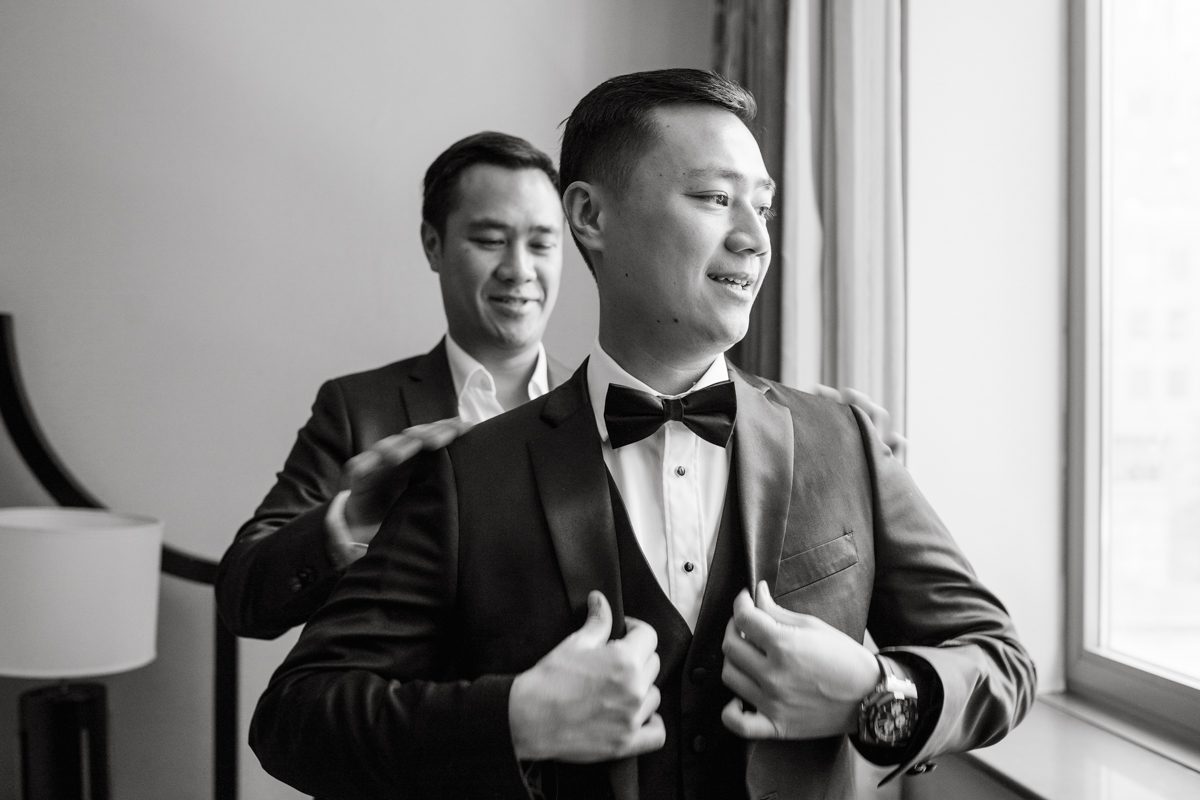 Duffield St, Brooklyn on November 19 even though it's Saturday morning it was still very busy. But luckily I found street parking right on Duffield St in front of Sheraton Downtown Brooklyn which was where I needed to be for Ariana and Jon's wedding prep. Vicky from VickyC5 hair/makeup team was there beautifying the ladies, I went straight to flat lays of Ariana's wedding details such as rings, jewelry and her wedding invitations. I use ribbons, extra loose flowers to make the flat lays more fine art looking. Once all the details are done, my full focus goes to the bride Ariana and her ladies. Ariana and Jon were planning to do a Chinese Door Game at the hotel room, so as soon as Ariana was ready in her Hanbok (Korean Traditional Wedding Outfit) Jon and his groomsmen arrived at the door. With Ariana's bridal suite crowded with too many people Ariana's bridesmaids started to give instructions to the games that Jon and his groomsmen need to play in order to get through the second door so that Jon can meet/see his bride Ariana. While the games are happening outside Ariana's door one of the bridesmaid has her phone on FaceTime so that Ariana can see how the men are doing during all the door games. I of course had my second shooter inside the room with Ariana to get her reactions which was hilarious. After the door games, we then moved to a conference room of at Sheraton Downtown Brooklyn for Ariana and Jon's Chinese Tea Pouring Ceremony (this is Jon's Chinese side's wedding tradition where you pour tea to all the elders in the family). Once all the Chines and Korean wedding traditions are over, we all rushed to Brooklyn Botanical Garden. Traffic from Sheraton Downtown Brooklyn to Brooklyn Botanical Garden was pretty bad, as usual. Once I arrived there of course was no street parking available near the entrance and parking lot for Brooklyn Botanical Garden was way too far for me to carry all the gears. After driving around I found one spot few blocks away from the Brooklyn Botanical Garden entrance. Brooklyn Botanical Garden was busy with Lightscape preparation and installation which we were not allowed to photograph so we were left with very little options for wedding portrait backdrop, plus it was COLD and we were looking light! These are important things to consider when you are planning for Winter wedding. I worked as quickly as possible with Ariana and Jon's first look and bridal party photos. Then we stayed inside for family photos since elders did not wanted to go outside which I totally don't blame. Then I quickly took Ariana and Jon outside for bit more couple's portraits then it was time for the wedding ceremony. Ariana and Jon's wedding ceremony held place at The Palm House at Brooklyn Botanical Garden, but because it was an winter wedding we've lost all the light and I had to use my video lights but over all the ceremony was beautiful and Oh Fleur NYC did absolutely an amazing job with ceremony decor (floral/candles). The Palm House was empty again, OhfleurNYC as well as Brooklyn Botanical Garden staff were busy turning the room. Oh Fleur NYC's Jessica's talent was amazing her usage of floral, choice of colors and mixing the floral with tall candles were magical. Turned The Palm House into a beautiful and romantic garden. Warmth of candles, peach and pinks of flowers all blended so well turning the Palm House at Brooklyn Botanical Garden in to fairytale floral ballroom. Ariana and Jon attended cocktail enjoying their time with friends and family before their wedding reception at The Palm House. Ariana and Jon's wedding at The Palm House at Brooklyn Botanical Garden documented by Karis from Hey Karis New York, Brooklyn, Hudson Valley and Catskills Wedding Photographer and NYC Elopement Photographer.