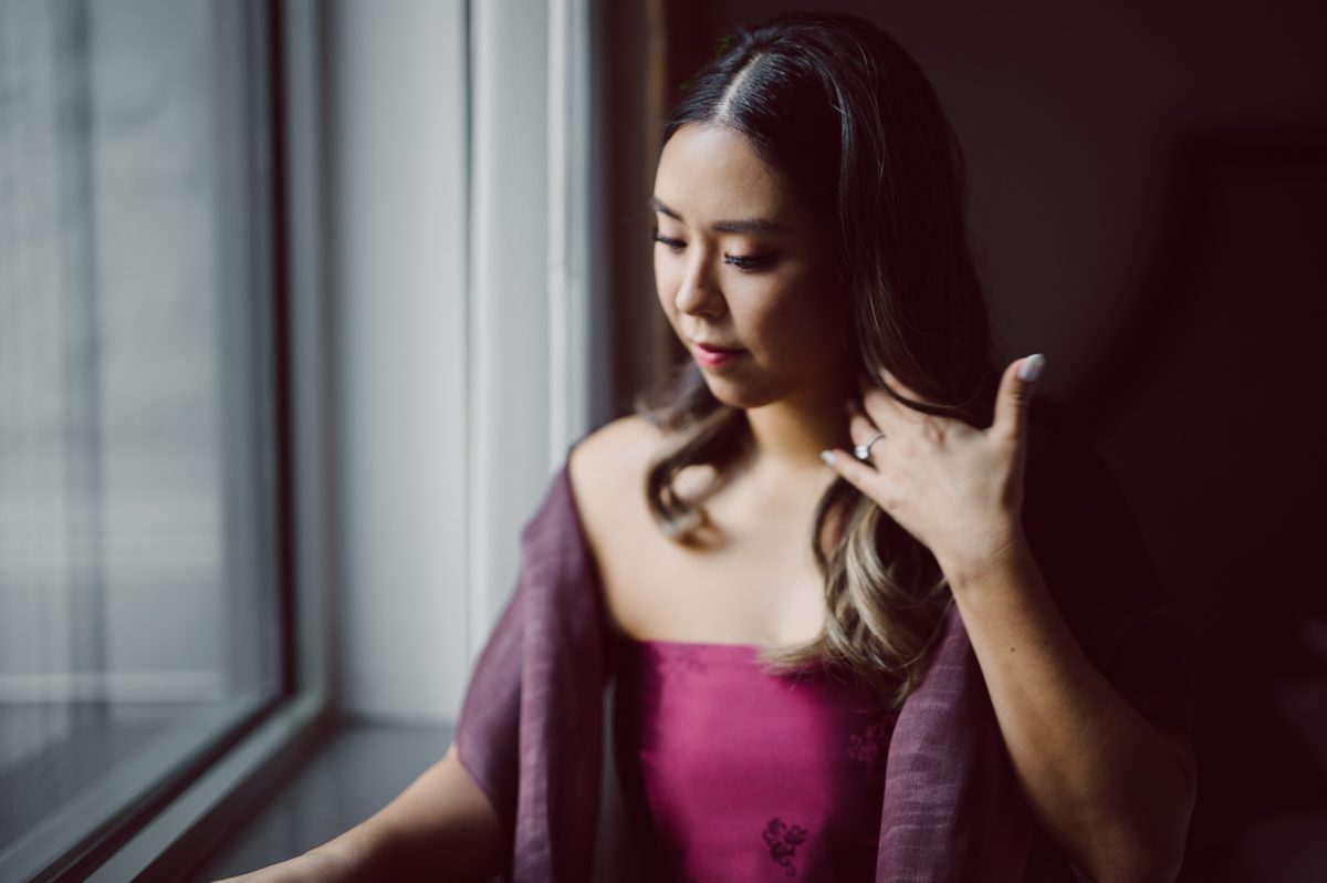 Duffield St, Brooklyn on November 19 even though it's Saturday morning it was still very busy. But luckily I found street parking right on Duffield St in front of Sheraton Downtown Brooklyn which was where I needed to be for Ariana and Jon's wedding prep. Vicky from VickyC5 hair/makeup team was there beautifying the ladies, I went straight to flat lays of Ariana's wedding details such as rings, jewelry and her wedding invitations. I use ribbons, extra loose flowers to make the flat lays more fine art looking. Once all the details are done, my full focus goes to the bride Ariana and her ladies. Ariana and Jon were planning to do a Chinese Door Game at the hotel room, so as soon as Ariana was ready in her Hanbok (Korean Traditional Wedding Outfit) Jon and his groomsmen arrived at the door. With Ariana's bridal suite crowded with too many people Ariana's bridesmaids started to give instructions to the games that Jon and his groomsmen need to play in order to get through the second door so that Jon can meet/see his bride Ariana. While the games are happening outside Ariana's door one of the bridesmaid has her phone on FaceTime so that Ariana can see how the men are doing during all the door games. I of course had my second shooter inside the room with Ariana to get her reactions which was hilarious. After the door games, we then moved to a conference room of at Sheraton Downtown Brooklyn for Ariana and Jon's Chinese Tea Pouring Ceremony (this is Jon's Chinese side's wedding tradition where you pour tea to all the elders in the family). Once all the Chines and Korean wedding traditions are over, we all rushed to Brooklyn Botanical Garden. Traffic from Sheraton Downtown Brooklyn to Brooklyn Botanical Garden was pretty bad, as usual. Once I arrived there of course was no street parking available near the entrance and parking lot for Brooklyn Botanical Garden was way too far for me to carry all the gears. After driving around I found one spot few blocks away from the Brooklyn Botanical Garden entrance. Brooklyn Botanical Garden was busy with Lightscape preparation and installation which we were not allowed to photograph so we were left with very little options for wedding portrait backdrop, plus it was COLD and we were looking light! These are important things to consider when you are planning for Winter wedding. I worked as quickly as possible with Ariana and Jon's first look and bridal party photos. Then we stayed inside for family photos since elders did not wanted to go outside which I totally don't blame. Then I quickly took Ariana and Jon outside for bit more couple's portraits then it was time for the wedding ceremony. Ariana and Jon's wedding ceremony held place at The Palm House at Brooklyn Botanical Garden, but because it was an winter wedding we've lost all the light and I had to use my video lights but over all the ceremony was beautiful and Oh Fleur NYC did absolutely an amazing job with ceremony decor (floral/candles). The Palm House was empty again, OhfleurNYC as well as Brooklyn Botanical Garden staff were busy turning the room. Oh Fleur NYC's Jessica's talent was amazing her usage of floral, choice of colors and mixing the floral with tall candles were magical. Turned The Palm House into a beautiful and romantic garden. Warmth of candles, peach and pinks of flowers all blended so well turning the Palm House at Brooklyn Botanical Garden in to fairytale floral ballroom. Ariana and Jon attended cocktail enjoying their time with friends and family before their wedding reception at The Palm House. Ariana and Jon's wedding at The Palm House at Brooklyn Botanical Garden documented by Karis from Hey Karis New York, Brooklyn, Hudson Valley and Catskills Wedding Photographer and NYC Elopement Photographer.