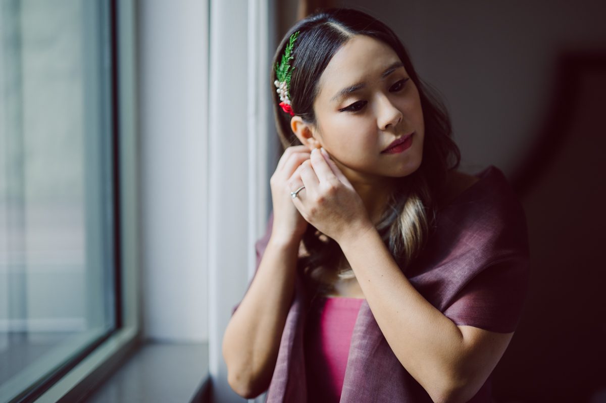 Duffield St, Brooklyn on November 19 even though it's Saturday morning it was still very busy. But luckily I found street parking right on Duffield St in front of Sheraton Downtown Brooklyn which was where I needed to be for Ariana and Jon's wedding prep. Vicky from VickyC5 hair/makeup team was there beautifying the ladies, I went straight to flat lays of Ariana's wedding details such as rings, jewelry and her wedding invitations. I use ribbons, extra loose flowers to make the flat lays more fine art looking. Once all the details are done, my full focus goes to the bride Ariana and her ladies. Ariana and Jon were planning to do a Chinese Door Game at the hotel room, so as soon as Ariana was ready in her Hanbok (Korean Traditional Wedding Outfit) Jon and his groomsmen arrived at the door. With Ariana's bridal suite crowded with too many people Ariana's bridesmaids started to give instructions to the games that Jon and his groomsmen need to play in order to get through the second door so that Jon can meet/see his bride Ariana. While the games are happening outside Ariana's door one of the bridesmaid has her phone on FaceTime so that Ariana can see how the men are doing during all the door games. I of course had my second shooter inside the room with Ariana to get her reactions which was hilarious. After the door games, we then moved to a conference room of at Sheraton Downtown Brooklyn for Ariana and Jon's Chinese Tea Pouring Ceremony (this is Jon's Chinese side's wedding tradition where you pour tea to all the elders in the family). Once all the Chines and Korean wedding traditions are over, we all rushed to Brooklyn Botanical Garden. Traffic from Sheraton Downtown Brooklyn to Brooklyn Botanical Garden was pretty bad, as usual. Once I arrived there of course was no street parking available near the entrance and parking lot for Brooklyn Botanical Garden was way too far for me to carry all the gears. After driving around I found one spot few blocks away from the Brooklyn Botanical Garden entrance. Brooklyn Botanical Garden was busy with Lightscape preparation and installation which we were not allowed to photograph so we were left with very little options for wedding portrait backdrop, plus it was COLD and we were looking light! These are important things to consider when you are planning for Winter wedding. I worked as quickly as possible with Ariana and Jon's first look and bridal party photos. Then we stayed inside for family photos since elders did not wanted to go outside which I totally don't blame. Then I quickly took Ariana and Jon outside for bit more couple's portraits then it was time for the wedding ceremony. Ariana and Jon's wedding ceremony held place at The Palm House at Brooklyn Botanical Garden, but because it was an winter wedding we've lost all the light and I had to use my video lights but over all the ceremony was beautiful and Oh Fleur NYC did absolutely an amazing job with ceremony decor (floral/candles). The Palm House was empty again, OhfleurNYC as well as Brooklyn Botanical Garden staff were busy turning the room. Oh Fleur NYC's Jessica's talent was amazing her usage of floral, choice of colors and mixing the floral with tall candles were magical. Turned The Palm House into a beautiful and romantic garden. Warmth of candles, peach and pinks of flowers all blended so well turning the Palm House at Brooklyn Botanical Garden in to fairytale floral ballroom. Ariana and Jon attended cocktail enjoying their time with friends and family before their wedding reception at The Palm House. Ariana and Jon's wedding at The Palm House at Brooklyn Botanical Garden documented by Karis from Hey Karis New York, Brooklyn, Hudson Valley and Catskills Wedding Photographer and NYC Elopement Photographer.