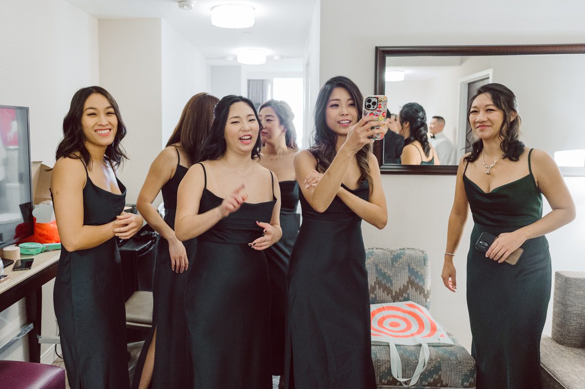 Duffield St, Brooklyn on November 19 even though it's Saturday morning it was still very busy. But luckily I found street parking right on Duffield St in front of Sheraton Downtown Brooklyn which was where I needed to be for Ariana and Jon's wedding prep. Vicky from VickyC5 hair/makeup team was there beautifying the ladies, I went straight to flat lays of Ariana's wedding details such as rings, jewelry and her wedding invitations. I use ribbons, extra loose flowers to make the flat lays more fine art looking. Once all the details are done, my full focus goes to the bride Ariana and her ladies. Ariana and Jon were planning to do a Chinese Door Game at the hotel room, so as soon as Ariana was ready in her Hanbok (Korean Traditional Wedding Outfit) Jon and his groomsmen arrived at the door. With Ariana's bridal suite crowded with too many people Ariana's bridesmaids started to give instructions to the games that Jon and his groomsmen need to play in order to get through the second door so that Jon can meet/see his bride Ariana. While the games are happening outside Ariana's door one of the bridesmaid has her phone on FaceTime so that Ariana can see how the men are doing during all the door games. I of course had my second shooter inside the room with Ariana to get her reactions which was hilarious. After the door games, we then moved to a conference room of at Sheraton Downtown Brooklyn for Ariana and Jon's Chinese Tea Pouring Ceremony (this is Jon's Chinese side's wedding tradition where you pour tea to all the elders in the family). Once all the Chines and Korean wedding traditions are over, we all rushed to Brooklyn Botanical Garden. Traffic from Sheraton Downtown Brooklyn to Brooklyn Botanical Garden was pretty bad, as usual. Once I arrived there of course was no street parking available near the entrance and parking lot for Brooklyn Botanical Garden was way too far for me to carry all the gears. After driving around I found one spot few blocks away from the Brooklyn Botanical Garden entrance. Brooklyn Botanical Garden was busy with Lightscape preparation and installation which we were not allowed to photograph so we were left with very little options for wedding portrait backdrop, plus it was COLD and we were looking light! These are important things to consider when you are planning for Winter wedding. I worked as quickly as possible with Ariana and Jon's first look and bridal party photos. Then we stayed inside for family photos since elders did not wanted to go outside which I totally don't blame. Then I quickly took Ariana and Jon outside for bit more couple's portraits then it was time for the wedding ceremony. Ariana and Jon's wedding ceremony held place at The Palm House at Brooklyn Botanical Garden, but because it was an winter wedding we've lost all the light and I had to use my video lights but over all the ceremony was beautiful and Oh Fleur NYC did absolutely an amazing job with ceremony decor (floral/candles). The Palm House was empty again, OhfleurNYC as well as Brooklyn Botanical Garden staff were busy turning the room. Oh Fleur NYC's Jessica's talent was amazing her usage of floral, choice of colors and mixing the floral with tall candles were magical. Turned The Palm House into a beautiful and romantic garden. Warmth of candles, peach and pinks of flowers all blended so well turning the Palm House at Brooklyn Botanical Garden in to fairytale floral ballroom. Ariana and Jon attended cocktail enjoying their time with friends and family before their wedding reception at The Palm House. Ariana and Jon's wedding at The Palm House at Brooklyn Botanical Garden documented by Karis from Hey Karis New York, Brooklyn, Hudson Valley and Catskills Wedding Photographer and NYC Elopement Photographer.