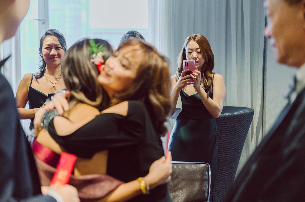 Duffield St, Brooklyn on November 19 even though it's Saturday morning it was still very busy. But luckily I found street parking right on Duffield St in front of Sheraton Downtown Brooklyn which was where I needed to be for Ariana and Jon's wedding prep. Vicky from VickyC5 hair/makeup team was there beautifying the ladies, I went straight to flat lays of Ariana's wedding details such as rings, jewelry and her wedding invitations. I use ribbons, extra loose flowers to make the flat lays more fine art looking. Once all the details are done, my full focus goes to the bride Ariana and her ladies. Ariana and Jon were planning to do a Chinese Door Game at the hotel room, so as soon as Ariana was ready in her Hanbok (Korean Traditional Wedding Outfit) Jon and his groomsmen arrived at the door. With Ariana's bridal suite crowded with too many people Ariana's bridesmaids started to give instructions to the games that Jon and his groomsmen need to play in order to get through the second door so that Jon can meet/see his bride Ariana. While the games are happening outside Ariana's door one of the bridesmaid has her phone on FaceTime so that Ariana can see how the men are doing during all the door games. I of course had my second shooter inside the room with Ariana to get her reactions which was hilarious. After the door games, we then moved to a conference room of at Sheraton Downtown Brooklyn for Ariana and Jon's Chinese Tea Pouring Ceremony (this is Jon's Chinese side's wedding tradition where you pour tea to all the elders in the family). Once all the Chines and Korean wedding traditions are over, we all rushed to Brooklyn Botanical Garden. Traffic from Sheraton Downtown Brooklyn to Brooklyn Botanical Garden was pretty bad, as usual. Once I arrived there of course was no street parking available near the entrance and parking lot for Brooklyn Botanical Garden was way too far for me to carry all the gears. After driving around I found one spot few blocks away from the Brooklyn Botanical Garden entrance. Brooklyn Botanical Garden was busy with Lightscape preparation and installation which we were not allowed to photograph so we were left with very little options for wedding portrait backdrop, plus it was COLD and we were looking light! These are important things to consider when you are planning for Winter wedding. I worked as quickly as possible with Ariana and Jon's first look and bridal party photos. Then we stayed inside for family photos since elders did not wanted to go outside which I totally don't blame. Then I quickly took Ariana and Jon outside for bit more couple's portraits then it was time for the wedding ceremony. Ariana and Jon's wedding ceremony held place at The Palm House at Brooklyn Botanical Garden, but because it was an winter wedding we've lost all the light and I had to use my video lights but over all the ceremony was beautiful and Oh Fleur NYC did absolutely an amazing job with ceremony decor (floral/candles). The Palm House was empty again, OhfleurNYC as well as Brooklyn Botanical Garden staff were busy turning the room. Oh Fleur NYC's Jessica's talent was amazing her usage of floral, choice of colors and mixing the floral with tall candles were magical. Turned The Palm House into a beautiful and romantic garden. Warmth of candles, peach and pinks of flowers all blended so well turning the Palm House at Brooklyn Botanical Garden in to fairytale floral ballroom. Ariana and Jon attended cocktail enjoying their time with friends and family before their wedding reception at The Palm House. Ariana and Jon's wedding at The Palm House at Brooklyn Botanical Garden documented by Karis from Hey Karis New York, Brooklyn, Hudson Valley and Catskills Wedding Photographer and NYC Elopement Photographer.