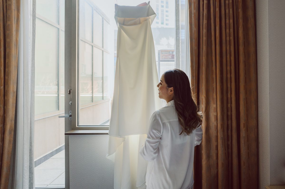 Duffield St, Brooklyn on November 19 even though it's Saturday morning it was still very busy. But luckily I found street parking right on Duffield St in front of Sheraton Downtown Brooklyn which was where I needed to be for Ariana and Jon's wedding prep. Vicky from VickyC5 hair/makeup team was there beautifying the ladies, I went straight to flat lays of Ariana's wedding details such as rings, jewelry and her wedding invitations. I use ribbons, extra loose flowers to make the flat lays more fine art looking. Once all the details are done, my full focus goes to the bride Ariana and her ladies. Ariana and Jon were planning to do a Chinese Door Game at the hotel room, so as soon as Ariana was ready in her Hanbok (Korean Traditional Wedding Outfit) Jon and his groomsmen arrived at the door. With Ariana's bridal suite crowded with too many people Ariana's bridesmaids started to give instructions to the games that Jon and his groomsmen need to play in order to get through the second door so that Jon can meet/see his bride Ariana. While the games are happening outside Ariana's door one of the bridesmaid has her phone on FaceTime so that Ariana can see how the men are doing during all the door games. I of course had my second shooter inside the room with Ariana to get her reactions which was hilarious. After the door games, we then moved to a conference room of at Sheraton Downtown Brooklyn for Ariana and Jon's Chinese Tea Pouring Ceremony (this is Jon's Chinese side's wedding tradition where you pour tea to all the elders in the family). Once all the Chines and Korean wedding traditions are over, we all rushed to Brooklyn Botanical Garden. Traffic from Sheraton Downtown Brooklyn to Brooklyn Botanical Garden was pretty bad, as usual. Once I arrived there of course was no street parking available near the entrance and parking lot for Brooklyn Botanical Garden was way too far for me to carry all the gears. After driving around I found one spot few blocks away from the Brooklyn Botanical Garden entrance. Brooklyn Botanical Garden was busy with Lightscape preparation and installation which we were not allowed to photograph so we were left with very little options for wedding portrait backdrop, plus it was COLD and we were looking light! These are important things to consider when you are planning for Winter wedding. I worked as quickly as possible with Ariana and Jon's first look and bridal party photos. Then we stayed inside for family photos since elders did not wanted to go outside which I totally don't blame. Then I quickly took Ariana and Jon outside for bit more couple's portraits then it was time for the wedding ceremony. Ariana and Jon's wedding ceremony held place at The Palm House at Brooklyn Botanical Garden, but because it was an winter wedding we've lost all the light and I had to use my video lights but over all the ceremony was beautiful and Oh Fleur NYC did absolutely an amazing job with ceremony decor (floral/candles). The Palm House was empty again, OhfleurNYC as well as Brooklyn Botanical Garden staff were busy turning the room. Oh Fleur NYC's Jessica's talent was amazing her usage of floral, choice of colors and mixing the floral with tall candles were magical. Turned The Palm House into a beautiful and romantic garden. Warmth of candles, peach and pinks of flowers all blended so well turning the Palm House at Brooklyn Botanical Garden in to fairytale floral ballroom. Ariana and Jon attended cocktail enjoying their time with friends and family before their wedding reception at The Palm House. Ariana and Jon's wedding at The Palm House at Brooklyn Botanical Garden documented by Karis from Hey Karis New York, Brooklyn, Hudson Valley and Catskills Wedding Photographer and NYC Elopement Photographer.