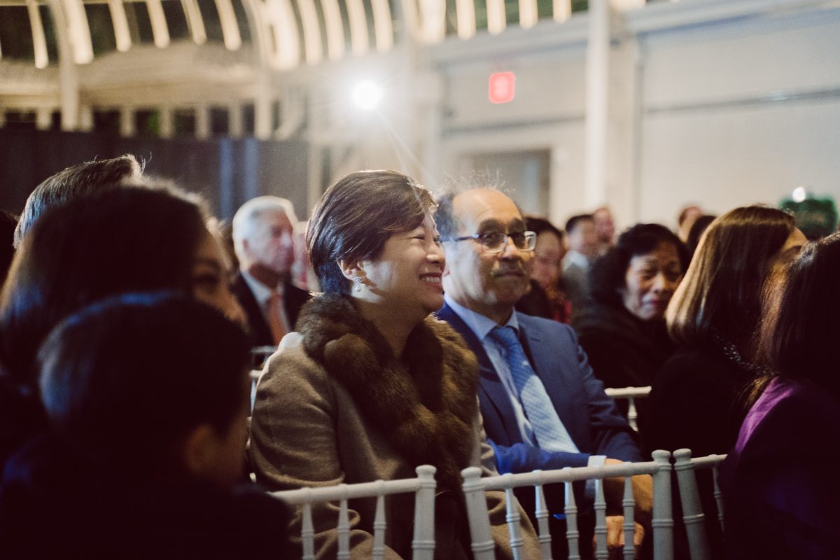 Duffield St, Brooklyn on November 19 even though it's Saturday morning it was still very busy. But luckily I found street parking right on Duffield St in front of Sheraton Downtown Brooklyn which was where I needed to be for Ariana and Jon's wedding prep. Vicky from VickyC5 hair/makeup team was there beautifying the ladies, I went straight to flat lays of Ariana's wedding details such as rings, jewelry and her wedding invitations. I use ribbons, extra loose flowers to make the flat lays more fine art looking. Once all the details are done, my full focus goes to the bride Ariana and her ladies. Ariana and Jon were planning to do a Chinese Door Game at the hotel room, so as soon as Ariana was ready in her Hanbok (Korean Traditional Wedding Outfit) Jon and his groomsmen arrived at the door. With Ariana's bridal suite crowded with too many people Ariana's bridesmaids started to give instructions to the games that Jon and his groomsmen need to play in order to get through the second door so that Jon can meet/see his bride Ariana. While the games are happening outside Ariana's door one of the bridesmaid has her phone on FaceTime so that Ariana can see how the men are doing during all the door games. I of course had my second shooter inside the room with Ariana to get her reactions which was hilarious. After the door games, we then moved to a conference room of at Sheraton Downtown Brooklyn for Ariana and Jon's Chinese Tea Pouring Ceremony (this is Jon's Chinese side's wedding tradition where you pour tea to all the elders in the family). Once all the Chines and Korean wedding traditions are over, we all rushed to Brooklyn Botanical Garden. Traffic from Sheraton Downtown Brooklyn to Brooklyn Botanical Garden was pretty bad, as usual. Once I arrived there of course was no street parking available near the entrance and parking lot for Brooklyn Botanical Garden was way too far for me to carry all the gears. After driving around I found one spot few blocks away from the Brooklyn Botanical Garden entrance. Brooklyn Botanical Garden was busy with Lightscape preparation and installation which we were not allowed to photograph so we were left with very little options for wedding portrait backdrop, plus it was COLD and we were looking light! These are important things to consider when you are planning for Winter wedding. I worked as quickly as possible with Ariana and Jon's first look and bridal party photos. Then we stayed inside for family photos since elders did not wanted to go outside which I totally don't blame. Then I quickly took Ariana and Jon outside for bit more couple's portraits then it was time for the wedding ceremony. Ariana and Jon's wedding ceremony held place at The Palm House at Brooklyn Botanical Garden, but because it was an winter wedding we've lost all the light and I had to use my video lights but over all the ceremony was beautiful and Oh Fleur NYC did absolutely an amazing job with ceremony decor (floral/candles). The Palm House was empty again, OhfleurNYC as well as Brooklyn Botanical Garden staff were busy turning the room. Oh Fleur NYC's Jessica's talent was amazing her usage of floral, choice of colors and mixing the floral with tall candles were magical. Turned The Palm House into a beautiful and romantic garden. Warmth of candles, peach and pinks of flowers all blended so well turning the Palm House at Brooklyn Botanical Garden in to fairytale floral ballroom. Ariana and Jon attended cocktail enjoying their time with friends and family before their wedding reception at The Palm House. Ariana and Jon's wedding at The Palm House at Brooklyn Botanical Garden documented by Karis from Hey Karis New York, Brooklyn, Hudson Valley and Catskills Wedding Photographer and NYC Elopement Photographer.