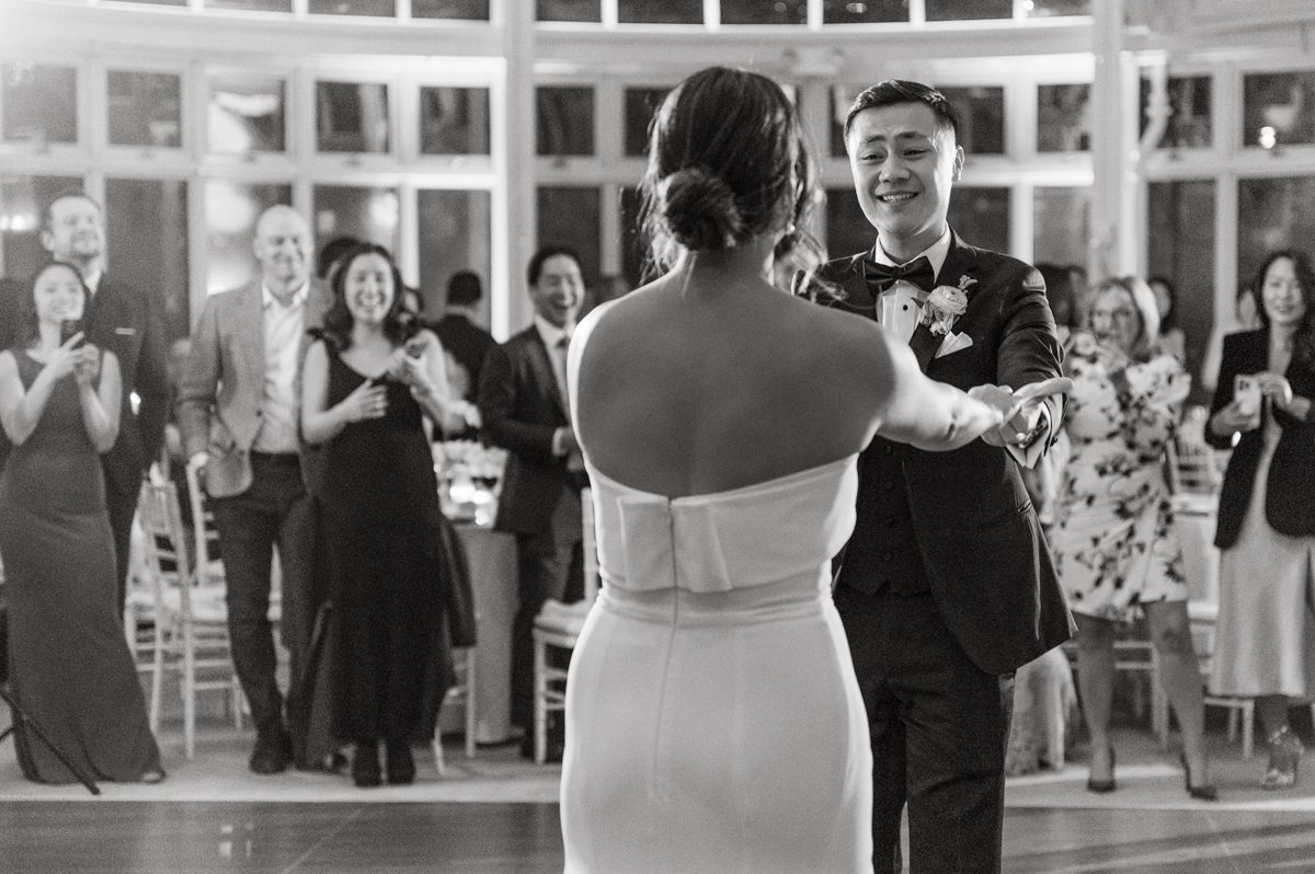 Duffield St, Brooklyn on November 19 even though it's Saturday morning it was still very busy. But luckily I found street parking right on Duffield St in front of Sheraton Downtown Brooklyn which was where I needed to be for Ariana and Jon's wedding prep. Vicky from VickyC5 hair/makeup team was there beautifying the ladies, I went straight to flat lays of Ariana's wedding details such as rings, jewelry and her wedding invitations. I use ribbons, extra loose flowers to make the flat lays more fine art looking. Once all the details are done, my full focus goes to the bride Ariana and her ladies. Ariana and Jon were planning to do a Chinese Door Game at the hotel room, so as soon as Ariana was ready in her Hanbok (Korean Traditional Wedding Outfit) Jon and his groomsmen arrived at the door. With Ariana's bridal suite crowded with too many people Ariana's bridesmaids started to give instructions to the games that Jon and his groomsmen need to play in order to get through the second door so that Jon can meet/see his bride Ariana. While the games are happening outside Ariana's door one of the bridesmaid has her phone on FaceTime so that Ariana can see how the men are doing during all the door games. I of course had my second shooter inside the room with Ariana to get her reactions which was hilarious. After the door games, we then moved to a conference room of at Sheraton Downtown Brooklyn for Ariana and Jon's Chinese Tea Pouring Ceremony (this is Jon's Chinese side's wedding tradition where you pour tea to all the elders in the family). Once all the Chines and Korean wedding traditions are over, we all rushed to Brooklyn Botanical Garden. Traffic from Sheraton Downtown Brooklyn to Brooklyn Botanical Garden was pretty bad, as usual. Once I arrived there of course was no street parking available near the entrance and parking lot for Brooklyn Botanical Garden was way too far for me to carry all the gears. After driving around I found one spot few blocks away from the Brooklyn Botanical Garden entrance. Brooklyn Botanical Garden was busy with Lightscape preparation and installation which we were not allowed to photograph so we were left with very little options for wedding portrait backdrop, plus it was COLD and we were looking light! These are important things to consider when you are planning for Winter wedding. I worked as quickly as possible with Ariana and Jon's first look and bridal party photos. Then we stayed inside for family photos since elders did not wanted to go outside which I totally don't blame. Then I quickly took Ariana and Jon outside for bit more couple's portraits then it was time for the wedding ceremony. Ariana and Jon's wedding ceremony held place at The Palm House at Brooklyn Botanical Garden, but because it was an winter wedding we've lost all the light and I had to use my video lights but over all the ceremony was beautiful and Oh Fleur NYC did absolutely an amazing job with ceremony decor (floral/candles). The Palm House was empty again, OhfleurNYC as well as Brooklyn Botanical Garden staff were busy turning the room. Oh Fleur NYC's Jessica's talent was amazing her usage of floral, choice of colors and mixing the floral with tall candles were magical. Turned The Palm House into a beautiful and romantic garden. Warmth of candles, peach and pinks of flowers all blended so well turning the Palm House at Brooklyn Botanical Garden in to fairytale floral ballroom. Ariana and Jon attended cocktail enjoying their time with friends and family before their wedding reception at The Palm House. Ariana and Jon's wedding at The Palm House at Brooklyn Botanical Garden documented by Karis from Hey Karis New York, Brooklyn, Hudson Valley and Catskills Wedding Photographer and NYC Elopement Photographer.