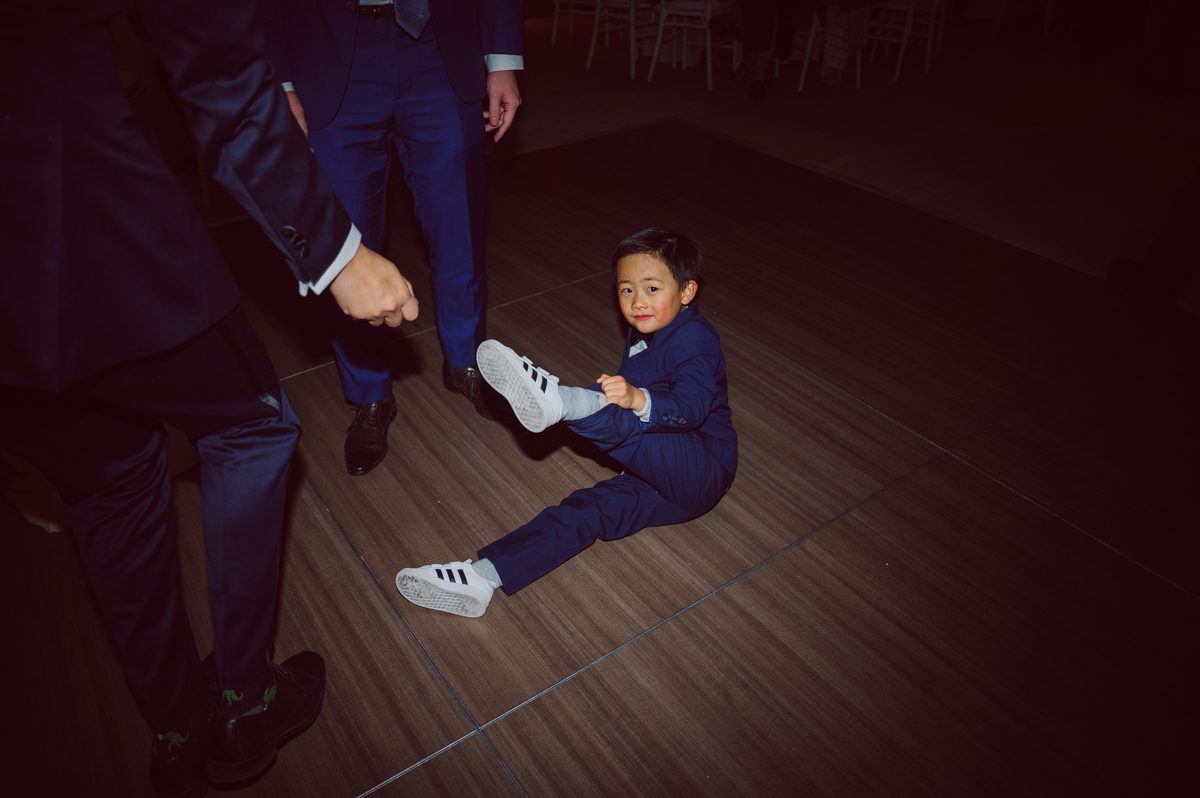 Duffield St, Brooklyn on November 19 even though it's Saturday morning it was still very busy. But luckily I found street parking right on Duffield St in front of Sheraton Downtown Brooklyn which was where I needed to be for Ariana and Jon's wedding prep. Vicky from VickyC5 hair/makeup team was there beautifying the ladies, I went straight to flat lays of Ariana's wedding details such as rings, jewelry and her wedding invitations. I use ribbons, extra loose flowers to make the flat lays more fine art looking. Once all the details are done, my full focus goes to the bride Ariana and her ladies. Ariana and Jon were planning to do a Chinese Door Game at the hotel room, so as soon as Ariana was ready in her Hanbok (Korean Traditional Wedding Outfit) Jon and his groomsmen arrived at the door. With Ariana's bridal suite crowded with too many people Ariana's bridesmaids started to give instructions to the games that Jon and his groomsmen need to play in order to get through the second door so that Jon can meet/see his bride Ariana. While the games are happening outside Ariana's door one of the bridesmaid has her phone on FaceTime so that Ariana can see how the men are doing during all the door games. I of course had my second shooter inside the room with Ariana to get her reactions which was hilarious. After the door games, we then moved to a conference room of at Sheraton Downtown Brooklyn for Ariana and Jon's Chinese Tea Pouring Ceremony (this is Jon's Chinese side's wedding tradition where you pour tea to all the elders in the family). Once all the Chines and Korean wedding traditions are over, we all rushed to Brooklyn Botanical Garden. Traffic from Sheraton Downtown Brooklyn to Brooklyn Botanical Garden was pretty bad, as usual. Once I arrived there of course was no street parking available near the entrance and parking lot for Brooklyn Botanical Garden was way too far for me to carry all the gears. After driving around I found one spot few blocks away from the Brooklyn Botanical Garden entrance. Brooklyn Botanical Garden was busy with Lightscape preparation and installation which we were not allowed to photograph so we were left with very little options for wedding portrait backdrop, plus it was COLD and we were looking light! These are important things to consider when you are planning for Winter wedding. I worked as quickly as possible with Ariana and Jon's first look and bridal party photos. Then we stayed inside for family photos since elders did not wanted to go outside which I totally don't blame. Then I quickly took Ariana and Jon outside for bit more couple's portraits then it was time for the wedding ceremony. Ariana and Jon's wedding ceremony held place at The Palm House at Brooklyn Botanical Garden, but because it was an winter wedding we've lost all the light and I had to use my video lights but over all the ceremony was beautiful and Oh Fleur NYC did absolutely an amazing job with ceremony decor (floral/candles). The Palm House was empty again, OhfleurNYC as well as Brooklyn Botanical Garden staff were busy turning the room. Oh Fleur NYC's Jessica's talent was amazing her usage of floral, choice of colors and mixing the floral with tall candles were magical. Turned The Palm House into a beautiful and romantic garden. Warmth of candles, peach and pinks of flowers all blended so well turning the Palm House at Brooklyn Botanical Garden in to fairytale floral ballroom. Ariana and Jon attended cocktail enjoying their time with friends and family before their wedding reception at The Palm House. Ariana and Jon's wedding at The Palm House at Brooklyn Botanical Garden documented by Karis from Hey Karis New York, Brooklyn, Hudson Valley and Catskills Wedding Photographer and NYC Elopement Photographer.