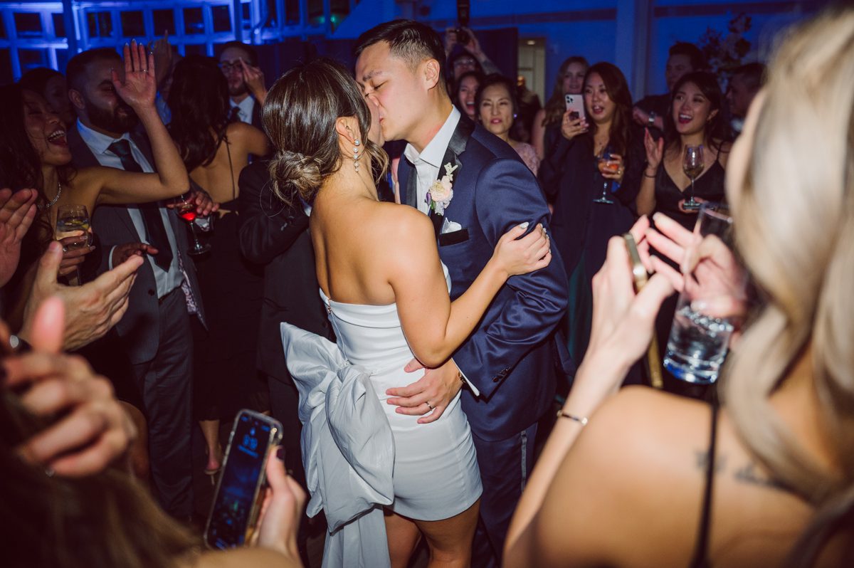 Duffield St, Brooklyn on November 19 even though it's Saturday morning it was still very busy. But luckily I found street parking right on Duffield St in front of Sheraton Downtown Brooklyn which was where I needed to be for Ariana and Jon's wedding prep. Vicky from VickyC5 hair/makeup team was there beautifying the ladies, I went straight to flat lays of Ariana's wedding details such as rings, jewelry and her wedding invitations. I use ribbons, extra loose flowers to make the flat lays more fine art looking. Once all the details are done, my full focus goes to the bride Ariana and her ladies. Ariana and Jon were planning to do a Chinese Door Game at the hotel room, so as soon as Ariana was ready in her Hanbok (Korean Traditional Wedding Outfit) Jon and his groomsmen arrived at the door. With Ariana's bridal suite crowded with too many people Ariana's bridesmaids started to give instructions to the games that Jon and his groomsmen need to play in order to get through the second door so that Jon can meet/see his bride Ariana. While the games are happening outside Ariana's door one of the bridesmaid has her phone on FaceTime so that Ariana can see how the men are doing during all the door games. I of course had my second shooter inside the room with Ariana to get her reactions which was hilarious. After the door games, we then moved to a conference room of at Sheraton Downtown Brooklyn for Ariana and Jon's Chinese Tea Pouring Ceremony (this is Jon's Chinese side's wedding tradition where you pour tea to all the elders in the family). Once all the Chines and Korean wedding traditions are over, we all rushed to Brooklyn Botanical Garden. Traffic from Sheraton Downtown Brooklyn to Brooklyn Botanical Garden was pretty bad, as usual. Once I arrived there of course was no street parking available near the entrance and parking lot for Brooklyn Botanical Garden was way too far for me to carry all the gears. After driving around I found one spot few blocks away from the Brooklyn Botanical Garden entrance. Brooklyn Botanical Garden was busy with Lightscape preparation and installation which we were not allowed to photograph so we were left with very little options for wedding portrait backdrop, plus it was COLD and we were looking light! These are important things to consider when you are planning for Winter wedding. I worked as quickly as possible with Ariana and Jon's first look and bridal party photos. Then we stayed inside for family photos since elders did not wanted to go outside which I totally don't blame. Then I quickly took Ariana and Jon outside for bit more couple's portraits then it was time for the wedding ceremony. Ariana and Jon's wedding ceremony held place at The Palm House at Brooklyn Botanical Garden, but because it was an winter wedding we've lost all the light and I had to use my video lights but over all the ceremony was beautiful and Oh Fleur NYC did absolutely an amazing job with ceremony decor (floral/candles). The Palm House was empty again, OhfleurNYC as well as Brooklyn Botanical Garden staff were busy turning the room. Oh Fleur NYC's Jessica's talent was amazing her usage of floral, choice of colors and mixing the floral with tall candles were magical. Turned The Palm House into a beautiful and romantic garden. Warmth of candles, peach and pinks of flowers all blended so well turning the Palm House at Brooklyn Botanical Garden in to fairytale floral ballroom. Ariana and Jon attended cocktail enjoying their time with friends and family before their wedding reception at The Palm House. Ariana and Jon's wedding at The Palm House at Brooklyn Botanical Garden documented by Karis from Hey Karis New York, Brooklyn, Hudson Valley and Catskills Wedding Photographer and NYC Elopement Photographer.