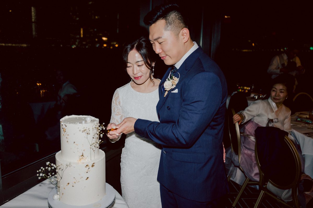 Chloe and Bosco are one of the sweetest couple!!! Well mannered, kind, sweet, considerate so I was extra excited for Chloe and Bosco's wedding at The Chart House. Chloe and Bosco both got ready at Chole's parents house in Oradell NJ where both sets of parents were all gathered. With no bridal party Chloe and Bosco had a quiet wedding morning. Midway through the morning prep, it started raining outside and did not look like we will be going outside for photos anytime soon or even till evening at Weehawken. With wishful mind of clear sky later, we got photos with family, parents and the couple at Chole's parent's house before leaving for Chloe and Bosco's wedding ceremony at St. Michaels Church in Fort Lee, NJ. St. Michales Church is small cute Korean Catholic church in Fort Lee, NJ where Chloe and Bosco belongs to. We can hear the rain falling down harder while getting group and family formal photos at St. Michaels Church before heading to Chart House in Weehawken NJ for Chloe and Bosco's intimate wedding reception. By the time we were in the car to drive over to Chart House, it was POURING. Chart House was busy with weekend customers enjoying the restaurant and they had three events going on upstairs! The entrance to Chart House was crowded with people coming and leaving waiting for the valet to bring their cars. Chloe and Bosco with help of their friends DIYed lots of wedding decor, music and games/entertainment during their wedding reception at Chart House. My heart really belongs to these small and intimate weddings where the couple focuses on them and what is really important to them instead of a big wedding celebration to show off of copy what they saw on social media. Sweet and lovely intimate wedding of Chloe and Bosco at Chart House Weehawken NJ wedding documented by by Karis | Hey Karis | Catskills, Hudson Valley NY elopement and wedding photographer | Brooklyn NY elopement and wedding photographer | Manhattan NY elopement and wedding photographer | Hey Karis is fun documentary wedding and elopement photographer.
