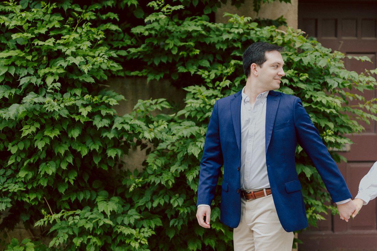 Washington Square Park along with University St as well as Washington Mews were all very quiet and empty Saturday morning. Unusually empty and that is when I realized NYU along with all colleges/universities were out for the summer which means all the students left NYC for the summer. Also meant we had the luxury of having the whole Washington Mews to ourselves during Renee and Sam's engagement session. We walked up and down the cobble stone street of Washington Mews choosing which backdrop, which colorful brick wall and which rustic door we liked best. Roses and green vines covered the walls of Washington Mews making us feel like as if we were in streets of Europe. Washington Mews is truly a gem in this concrete jungle called Manhattan. Renee and Sam's Washington Mews NY Engagement Session documented by by Karis | Hey Karis | Catskills, Hudson Valley NY elopement and wedding photographer | Brooklyn NY elopement and wedding photographer | Manhattan NY elopement and wedding photographer | Hey Karis is fun documentary wedding and elopement photographer.
