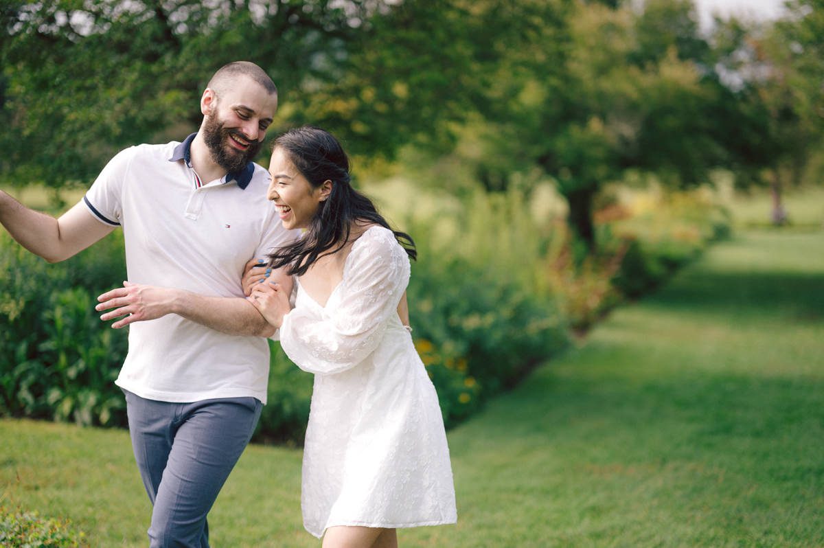 Ari and Kevin reached out with an intimate wedding plans and was pretty much ready to book me as soon as they got on the phone. Most intimate wedding couples opt out of engagement session but Ari knew she wanted an engagement session to celebrate their love before their intimate wedding in August. Ari and Kevin have very active lifestyle where they go climbing, hiking, running, etc...so by default they wanted an outdoor natury engagement session. We chose to meet at the botanical garden. Since we are in the middle of hot summer, we all agreed on early session when the park opened but even than 30mins into the engagement session it got real hot and humid. Ari not so much but Kevin was definitely started sweating. But Ari and Kevin along with their Corgi named Echo did amazing, we had so much fun as you can see from these photos of Ari, Kevin and Echo. Ari and Kevin's Botanical Garden engagement documented by by Karis | Hey Karis | Catskills, Hudson Valley NY elopement and wedding photographer | Brooklyn NY elopement and wedding photographer | Manhattan NY elopement and wedding photographer | Hey Karis is fun documentary wedding and elopement photographer.
