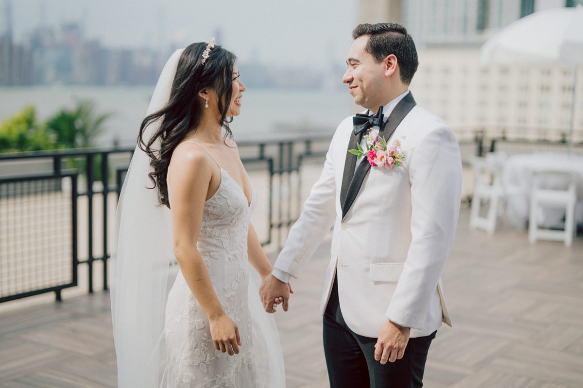 It's with immense joy that I share the unforgettable moments from Katherine and Omar's enchanting wedding day at The W Loft in Brooklyn, New York. Katherine and Omar saw each other for the first time rooftop of The W Loft with stunning backdrop of the city's skyline. The two spend some time talking and admiring each other during their first look, then as the moment finished and Katherine and Omar gave me the cue that they are ready to go to Domino Park (Williamsburg Bridge and the East River at the backdrop) was only around the corner from The W Loft for their wedding photos. We walked together with Katherine and Omar's bridal party to Domino Park, it was a typical hot NY summer on their wedding day and doing photos outside in the heat wasn't easy especially with so many people/crowd at Domino Park but we managed and even grabbed ice cream on the way back to The W Loft. Rooftop was busy setting up for Katherine and Omar's wedding ceremony with few guests already filing in the seats. Katherine and Omar's breathtaking wedding ceremony on The W Loft rooftop with Williamsburg Bridge to the side, the East River with city scape was a perfect backdrop for these New Yorkers to say their I do's. Then Katherine and Omar listened to sweet talks offered by their friends and family enjoyed their wedding reception. Katherine and Omar's The W Loft Brooklyn NY wedding documented by by Karis | Hey Karis | Catskills, Hudson Valley NY elopement and wedding photographer | Brooklyn NY elopement and wedding photographer | Manhattan NY elopement and wedding photographer | Hey Karis is fun documentary wedding and elopement photographer.