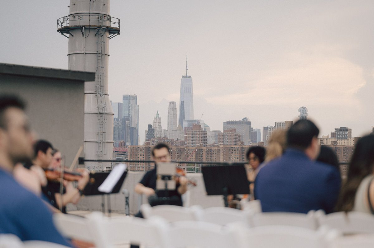 It's with immense joy that I share the unforgettable moments from Katherine and Omar's enchanting wedding day at The W Loft in Brooklyn, New York. Katherine and Omar saw each other for the first time rooftop of The W Loft with stunning backdrop of the city's skyline. The two spend some time talking and admiring each other during their first look, then as the moment finished and Katherine and Omar gave me the cue that they are ready to go to Domino Park (Williamsburg Bridge and the East River at the backdrop) was only around the corner from The W Loft for their wedding photos. We walked together with Katherine and Omar's bridal party to Domino Park, it was a typical hot NY summer on their wedding day and doing photos outside in the heat wasn't easy especially with so many people/crowd at Domino Park but we managed and even grabbed ice cream on the way back to The W Loft. Rooftop was busy setting up for Katherine and Omar's wedding ceremony with few guests already filing in the seats. Katherine and Omar's breathtaking wedding ceremony on The W Loft rooftop with Williamsburg Bridge to the side, the East River with city scape was a perfect backdrop for these New Yorkers to say their I do's. Then Katherine and Omar listened to sweet talks offered by their friends and family enjoyed their wedding reception. Katherine and Omar's The W Loft Brooklyn NY wedding documented by by Karis | Hey Karis | Catskills, Hudson Valley NY elopement and wedding photographer | Brooklyn NY elopement and wedding photographer | Manhattan NY elopement and wedding photographer | Hey Karis is fun documentary wedding and elopement photographer.