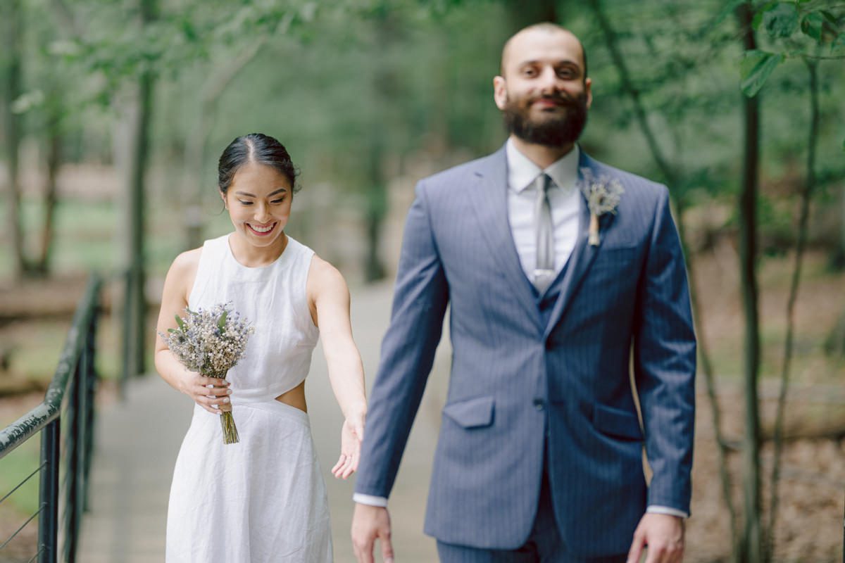 Ari and Kevin are big nature lovers, and they love the outdoors. For their intimate elopement they chose James A McFaul Environmental Center for their intimate wedding ceremony joined by their immediate family. Total of 10 people standing around Ari and Kevin surrounded by nature Ari & Kevin's sweetest wedding ceremony was held. Ari and Kevin looked at each other with the sweetest smiles it almost melted us. After the sweetest wedding ceremony at James A McFaul Environmental Center I took some wedding photos of Ari and Kevin then we left for Ari and Kevin's small and intimate dinner with family at Jockey Hollow Bar & Kitchen Morristown NJ. Morristown is such a beautiful town, and in front of Jockey Hollow Bar & Kitchen is such a picturesque backdrop with long water fountain, trees and flowers. So before Ari and Kevin sat down for their intimate dinner with family we walked around Morristown for quick photos. Then all 10 of them sat down in a private room at Jockey Hollow Bar & Kitchen to celebrate Ari and Kevin's union. Air and Kevin's James A McFaul Environmental Center and Jockey Hollow Bar & Kitchen Morristown NJ Elopement documented by by Karis | Hey Karis | Catskills, Hudson Valley NY elopement and wedding photographer | Brooklyn NY elopement and wedding photographer | Manhattan NY elopement and wedding photographer | Hey Karis is fun documentary wedding and elopement photographer.