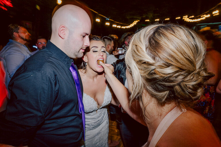 How do I explain the sincere and true feelings that Izzy and Brendan shared on their wedding day at one of the most magical place Arrow Park in Monroe NY. Izzy is Opera singer and Brendan is a Chef who owns his own restaurant called Circle in Newton, NJ got married at Arrow Park NY a month ago and it got real festive and wild real fast. But let's come back to the wild party in a bit and talk about their morning first. Izzy and Brendan both got ready onsite at Arrow Park, great thing about Arrow Park is that it has enough rooms to host all their bridal party and family. With all of Izzy and Brendan's loved ones onsite Izzy and Brendan's wedding prep was fun. No drama and no one running late, Izzy and Brendan's wedding prep went so smooth with everyone's cooperation! Izzy got into her dress with her mom and sister by her side, then we went down to the back steps for Izzy and Brendan's first look. Oh boy Brendan got super emotional for their first look, he couldn't even turn around to look at Izzy with all the happy emotions rushing to him. Izzy held his hand and they looked at each other. The two of them cried. Sharing such a beautiful first look Izzy and Brendan walked out to the front of Arrow Park for group and family photos. It was an August wedding so I kept everyone in the shade not too far, making it simple easy for group and family photos are important job to wedding photographer. After all the formal group photos were done, it was almost time for their wedding ceremony at the garden. Beautiful decor and floral arrangements were set up in the garden ready for Izzy and Brendan's wedding ceremony, guest started to walked down the long driveway and down the steps and found seats waited for the bride and groom to walk down the aisle. Brendan now standing in the front next to the priest, started tearing up as soon as he saw Izzy coming down the aisle escorted by her father. The two linked their eyes at each other and in the most loving way possible looked at each other through out the ceremony then sealed it with the first kiss as husband and wife. As calm and peaceful as Izzy and Brendan's wedding ceremony was, the two entered their reception each with (shaken) champagne bottles in their hands, everyone and anyone in Izzy and Brendan's way got sprayed with Champagne! They jumped, pouring Champagne into their friends mouth straight out of the bottle, then each drank some out of the bottle. Building the excitement in to their epic wedding party, Izzy and Brendan held each others hands and walked into the center of Arrow Park's courtyard and danced their first dance. Smoke and smell of freshly cooked dinner being prepared by Brendan's friends at Promises Kept Hudson Valley NY was filling the air, as first courses were being served. Happiest sound of plates, utensils and people chatting, Izzy and Brendan sat at their sweetheart table to enjoy their wedding dinner prepared by Promises Kept Hudson Valley NY. Then the evening got deeper and darker and vibe got stronger and crazier. Music got louder and everyone was in their element celebrating Izzy and Brendan on their wedding day. Izzy and Brendan's Arrow Park Monroe NY Wedding documented by by Karis | Hey Karis | Catskills, Hudson Valley NY elopement and wedding photographer | Brooklyn NY elopement and wedding photographer | Manhattan NY elopement and wedding photographer | Hey Karis is fun documentary wedding and elopement photographer.