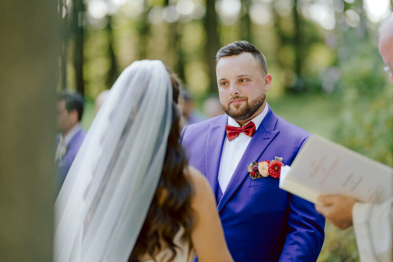 How do I explain the sincere and true feelings that Izzy and Brendan shared on their wedding day at one of the most magical place Arrow Park in Monroe NY. Izzy is Opera singer and Brendan is a Chef who owns his own restaurant called Circle in Newton, NJ got married at Arrow Park NY a month ago and it got real festive and wild real fast. But let's come back to the wild party in a bit and talk about their morning first. Izzy and Brendan both got ready onsite at Arrow Park, great thing about Arrow Park is that it has enough rooms to host all their bridal party and family. With all of Izzy and Brendan's loved ones onsite Izzy and Brendan's wedding prep was fun. No drama and no one running late, Izzy and Brendan's wedding prep went so smooth with everyone's cooperation! Izzy got into her dress with her mom and sister by her side, then we went down to the back steps for Izzy and Brendan's first look. Oh boy Brendan got super emotional for their first look, he couldn't even turn around to look at Izzy with all the happy emotions rushing to him. Izzy held his hand and they looked at each other. The two of them cried. Sharing such a beautiful first look Izzy and Brendan walked out to the front of Arrow Park for group and family photos. It was an August wedding so I kept everyone in the shade not too far, making it simple easy for group and family photos are important job to wedding photographer. After all the formal group photos were done, it was almost time for their wedding ceremony at the garden. Beautiful decor and floral arrangements were set up in the garden ready for Izzy and Brendan's wedding ceremony, guest started to walked down the long driveway and down the steps and found seats waited for the bride and groom to walk down the aisle. Brendan now standing in the front next to the priest, started tearing up as soon as he saw Izzy coming down the aisle escorted by her father. The two linked their eyes at each other and in the most loving way possible looked at each other through out the ceremony then sealed it with the first kiss as husband and wife. As calm and peaceful as Izzy and Brendan's wedding ceremony was, the two entered their reception each with (shaken) champagne bottles in their hands, everyone and anyone in Izzy and Brendan's way got sprayed with Champagne! They jumped, pouring Champagne into their friends mouth straight out of the bottle, then each drank some out of the bottle. Building the excitement in to their epic wedding party, Izzy and Brendan held each others hands and walked into the center of Arrow Park's courtyard and danced their first dance. Smoke and smell of freshly cooked dinner being prepared by Brendan's friends at Promises Kept Hudson Valley NY was filling the air, as first courses were being served. Happiest sound of plates, utensils and people chatting, Izzy and Brendan sat at their sweetheart table to enjoy their wedding dinner prepared by Promises Kept Hudson Valley NY. Then the evening got deeper and darker and vibe got stronger and crazier. Music got louder and everyone was in their element celebrating Izzy and Brendan on their wedding day. Izzy and Brendan's Arrow Park Monroe NY Wedding documented by by Karis | Hey Karis | Catskills, Hudson Valley NY elopement and wedding photographer | Brooklyn NY elopement and wedding photographer | Manhattan NY elopement and wedding photographer | Hey Karis is fun documentary wedding and elopement photographer.