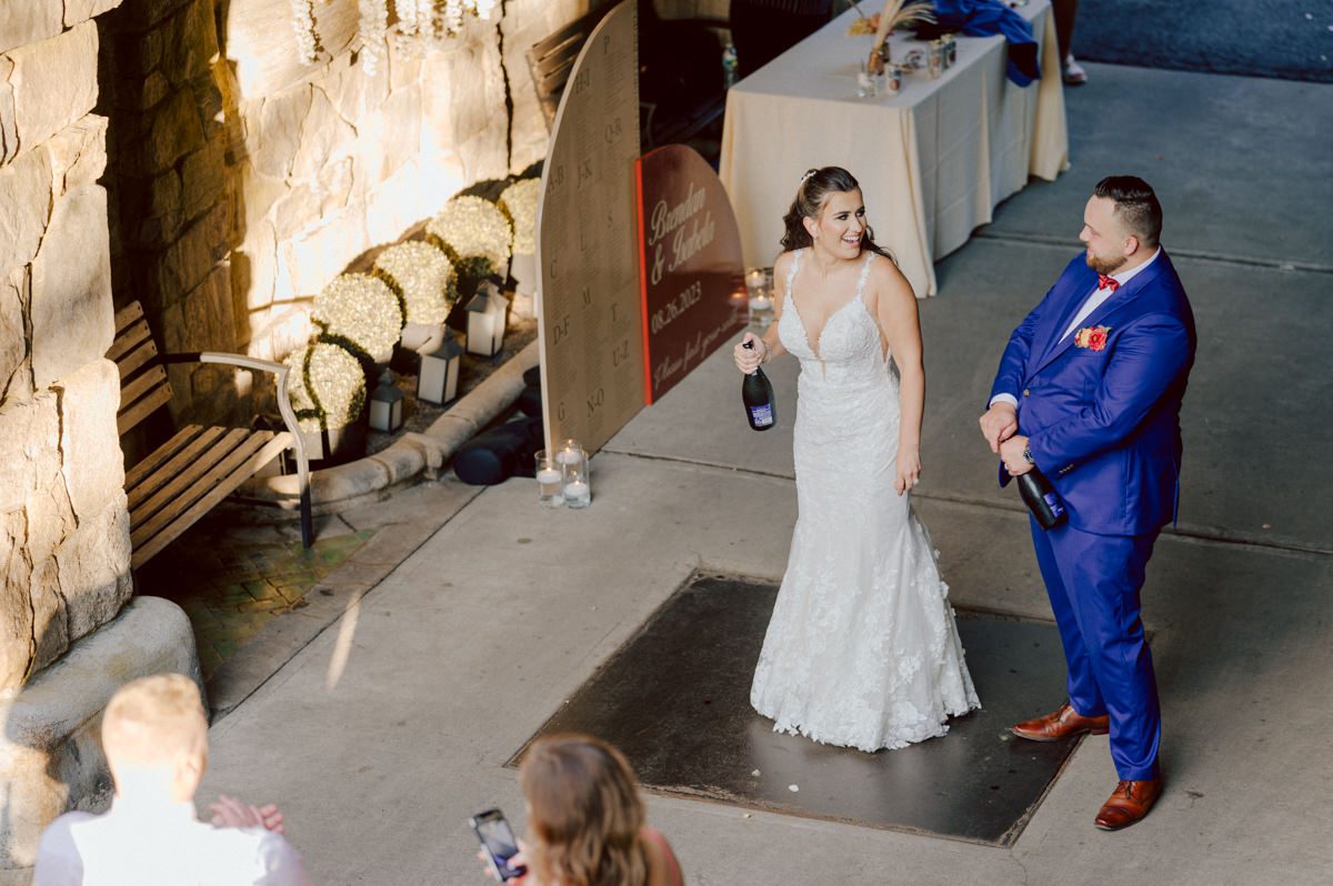 How do I explain the sincere and true feelings that Izzy and Brendan shared on their wedding day at one of the most magical place Arrow Park in Monroe NY. Izzy is Opera singer and Brendan is a Chef who owns his own restaurant called Circle in Newton, NJ got married at Arrow Park NY a month ago and it got real festive and wild real fast. But let's come back to the wild party in a bit and talk about their morning first. Izzy and Brendan both got ready onsite at Arrow Park, great thing about Arrow Park is that it has enough rooms to host all their bridal party and family. With all of Izzy and Brendan's loved ones onsite Izzy and Brendan's wedding prep was fun. No drama and no one running late, Izzy and Brendan's wedding prep went so smooth with everyone's cooperation! Izzy got into her dress with her mom and sister by her side, then we went down to the back steps for Izzy and Brendan's first look. Oh boy Brendan got super emotional for their first look, he couldn't even turn around to look at Izzy with all the happy emotions rushing to him. Izzy held his hand and they looked at each other. The two of them cried. Sharing such a beautiful first look Izzy and Brendan walked out to the front of Arrow Park for group and family photos. It was an August wedding so I kept everyone in the shade not too far, making it simple easy for group and family photos are important job to wedding photographer. After all the formal group photos were done, it was almost time for their wedding ceremony at the garden. Beautiful decor and floral arrangements were set up in the garden ready for Izzy and Brendan's wedding ceremony, guest started to walked down the long driveway and down the steps and found seats waited for the bride and groom to walk down the aisle. Brendan now standing in the front next to the priest, started tearing up as soon as he saw Izzy coming down the aisle escorted by her father. The two linked their eyes at each other and in the most loving way possible looked at each other through out the ceremony then sealed it with the first kiss as husband and wife. As calm and peaceful as Izzy and Brendan's wedding ceremony was, the two entered their reception each with (shaken) champagne bottles in their hands, everyone and anyone in Izzy and Brendan's way got sprayed with Champagne! They jumped, pouring Champagne into their friends mouth straight out of the bottle, then each drank some out of the bottle. Building the excitement in to their epic wedding party, Izzy and Brendan held each others hands and walked into the center of Arrow Park's courtyard and danced their first dance. Smoke and smell of freshly cooked dinner being prepared by Brendan's friends at Promises Kept Hudson Valley NY was filling the air, as first courses were being served. Happiest sound of plates, utensils and people chatting, Izzy and Brendan sat at their sweetheart table to enjoy their wedding dinner prepared by Promises Kept Hudson Valley NY. Then the evening got deeper and darker and vibe got stronger and crazier. Music got louder and everyone was in their element celebrating Izzy and Brendan on their wedding day. Izzy and Brendan's Arrow Park Monroe NY Wedding documented by by Karis | Hey Karis | Catskills, Hudson Valley NY elopement and wedding photographer | Brooklyn NY elopement and wedding photographer | Manhattan NY elopement and wedding photographer | Hey Karis is fun documentary wedding and elopement photographer.