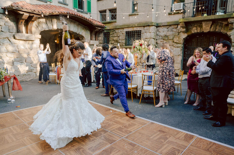How do I explain the sincere and true feelings that Izzy and Brendan shared on their wedding day at one of the most magical place Arrow Park in Monroe NY. Izzy is Opera singer and Brendan is a Chef who owns his own restaurant called Circle in Newton, NJ got married at Arrow Park NY a month ago and it got real festive and wild real fast. But let's come back to the wild party in a bit and talk about their morning first. Izzy and Brendan both got ready onsite at Arrow Park, great thing about Arrow Park is that it has enough rooms to host all their bridal party and family. With all of Izzy and Brendan's loved ones onsite Izzy and Brendan's wedding prep was fun. No drama and no one running late, Izzy and Brendan's wedding prep went so smooth with everyone's cooperation! Izzy got into her dress with her mom and sister by her side, then we went down to the back steps for Izzy and Brendan's first look. Oh boy Brendan got super emotional for their first look, he couldn't even turn around to look at Izzy with all the happy emotions rushing to him. Izzy held his hand and they looked at each other. The two of them cried. Sharing such a beautiful first look Izzy and Brendan walked out to the front of Arrow Park for group and family photos. It was an August wedding so I kept everyone in the shade not too far, making it simple easy for group and family photos are important job to wedding photographer. After all the formal group photos were done, it was almost time for their wedding ceremony at the garden. Beautiful decor and floral arrangements were set up in the garden ready for Izzy and Brendan's wedding ceremony, guest started to walked down the long driveway and down the steps and found seats waited for the bride and groom to walk down the aisle. Brendan now standing in the front next to the priest, started tearing up as soon as he saw Izzy coming down the aisle escorted by her father. The two linked their eyes at each other and in the most loving way possible looked at each other through out the ceremony then sealed it with the first kiss as husband and wife. As calm and peaceful as Izzy and Brendan's wedding ceremony was, the two entered their reception each with (shaken) champagne bottles in their hands, everyone and anyone in Izzy and Brendan's way got sprayed with Champagne! They jumped, pouring Champagne into their friends mouth straight out of the bottle, then each drank some out of the bottle. Building the excitement in to their epic wedding party, Izzy and Brendan held each others hands and walked into the center of Arrow Park's courtyard and danced their first dance. Smoke and smell of freshly cooked dinner being prepared by Brendan's friends at Promises Kept Hudson Valley NY was filling the air, as first courses were being served. Happiest sound of plates, utensils and people chatting, Izzy and Brendan sat at their sweetheart table to enjoy their wedding dinner prepared by Promises Kept Hudson Valley NY. Then the evening got deeper and darker and vibe got stronger and crazier. Music got louder and everyone was in their element celebrating Izzy and Brendan on their wedding day. Izzy and Brendan's Arrow Park Monroe NY Wedding documented by by Karis | Hey Karis | Catskills, Hudson Valley NY elopement and wedding photographer | Brooklyn NY elopement and wedding photographer | Manhattan NY elopement and wedding photographer | Hey Karis is fun documentary wedding and elopement photographer.